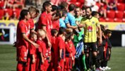 Adelaide United and Wellington Phoenix players shake hands before kick-off at Coopers Stadium on Sunday.