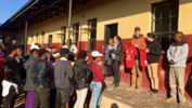 Morgan Brookes of Concordia College shows children of Bosheng Middle School Adelaide United gear to be donated to them.