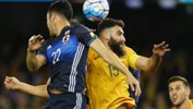 Mile Jedinak tussles for the ball with Japan's Maya Yoshida.