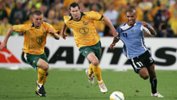 Brett Emerton fights for the ball with Uruguay's Mario Regueiro in 2005.