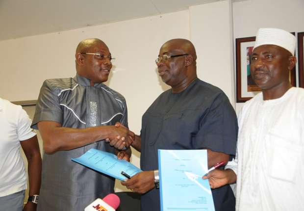 Stephen Keshi receives his new contract from Seyi Akinwunmi