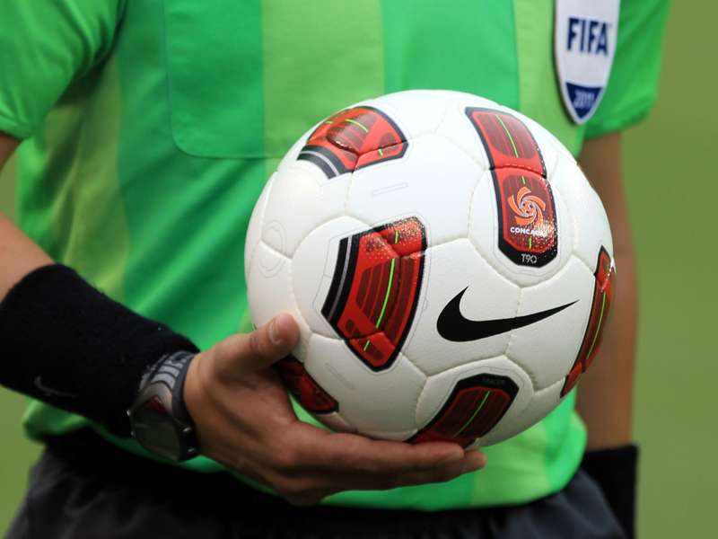 A referee carries the ball before a CONCACAF match
