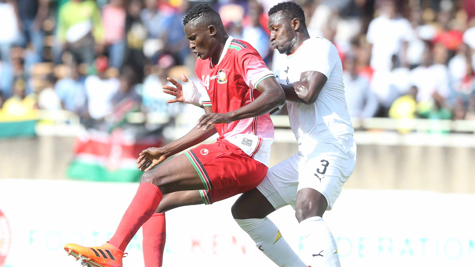 Michael Olunga of Kenya v Ghana defender.