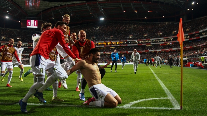 Aleksandar Mitrovic, swamped by his team-mates, celebrates after scoring a late winner for Serbia in Lisbon.