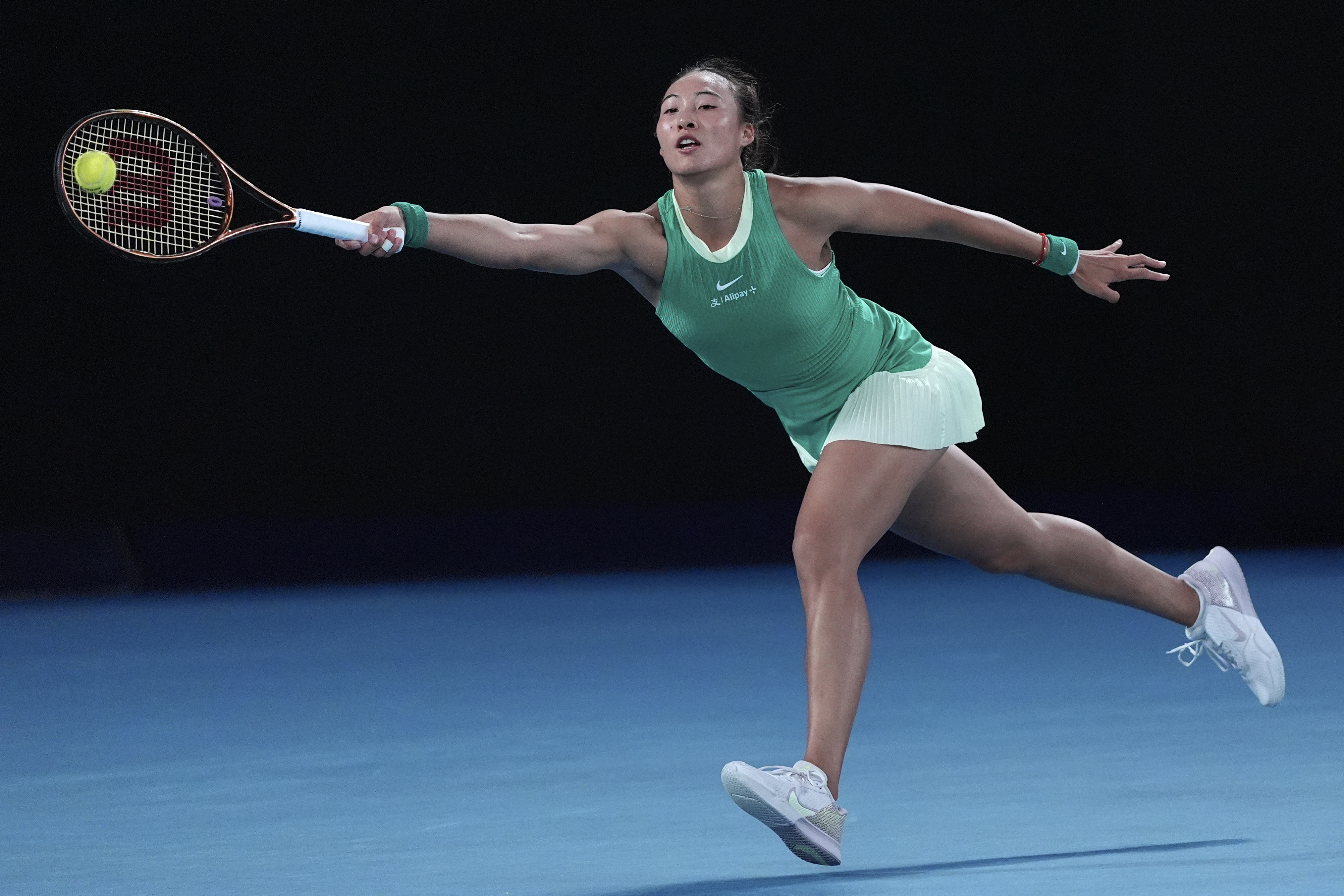 Zheng Qinwen stretches for a forehand