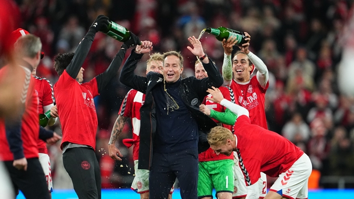 Denmark players celebrate with head coach Kasper Hjulmand after securing their 2022 World Cup spot