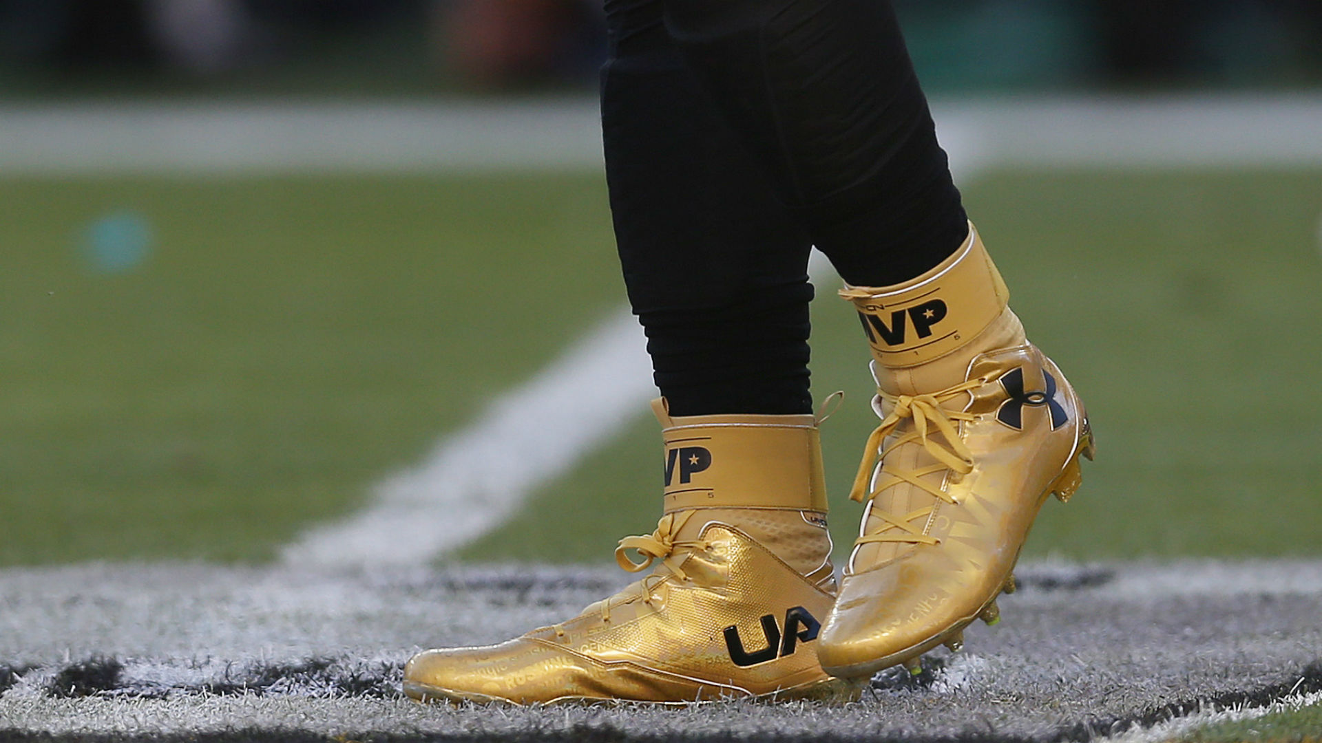 black and gold under armour football cleats