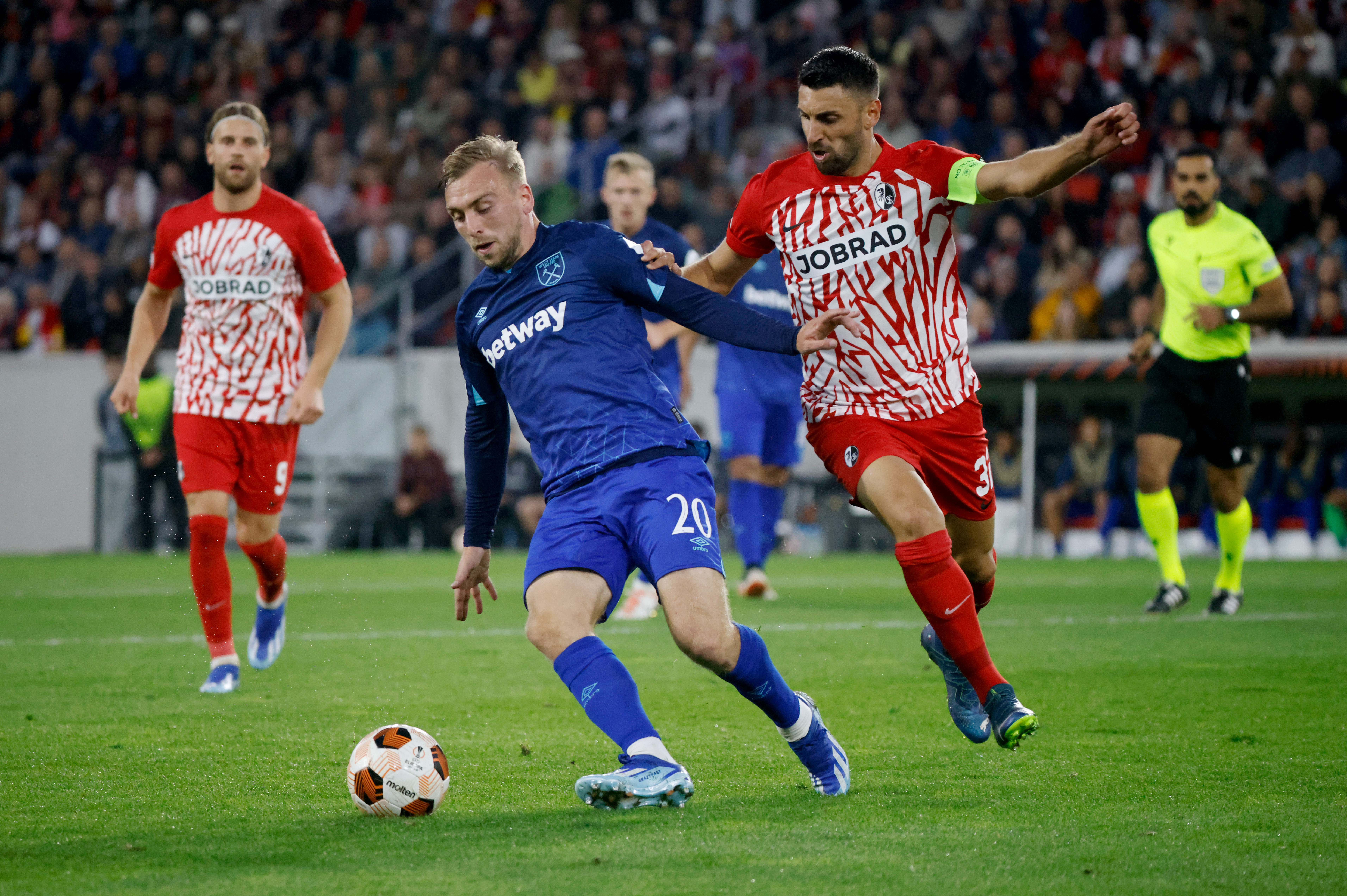 Freiburg’s Vincenzo Grifo, right, closes in on West Ham’s Jarrod Bowen during Thursday's Europa League clash in Germany