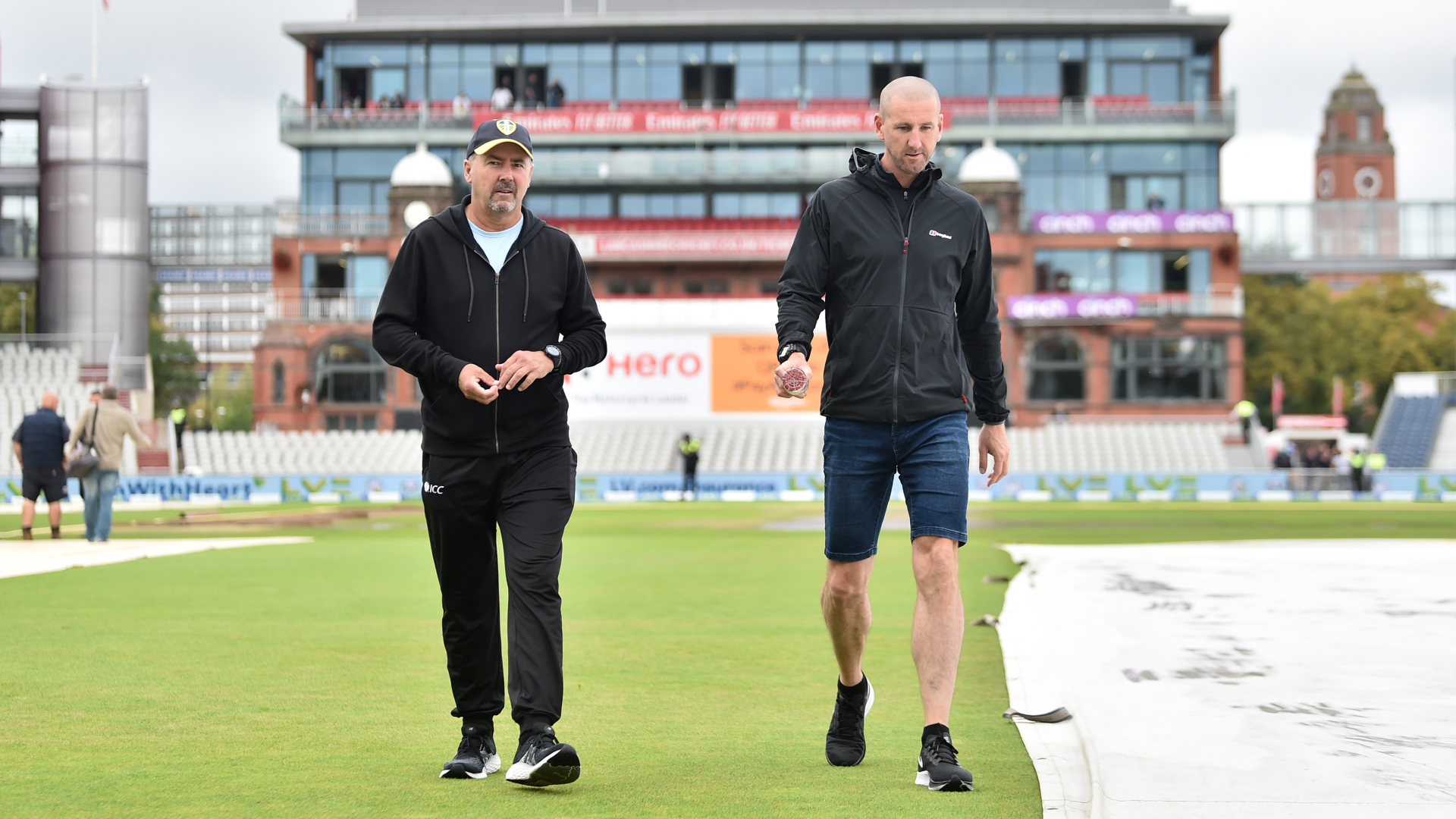 Umpires Richard Illingworth and Michael Gough inspect the pitch at Old Trafford