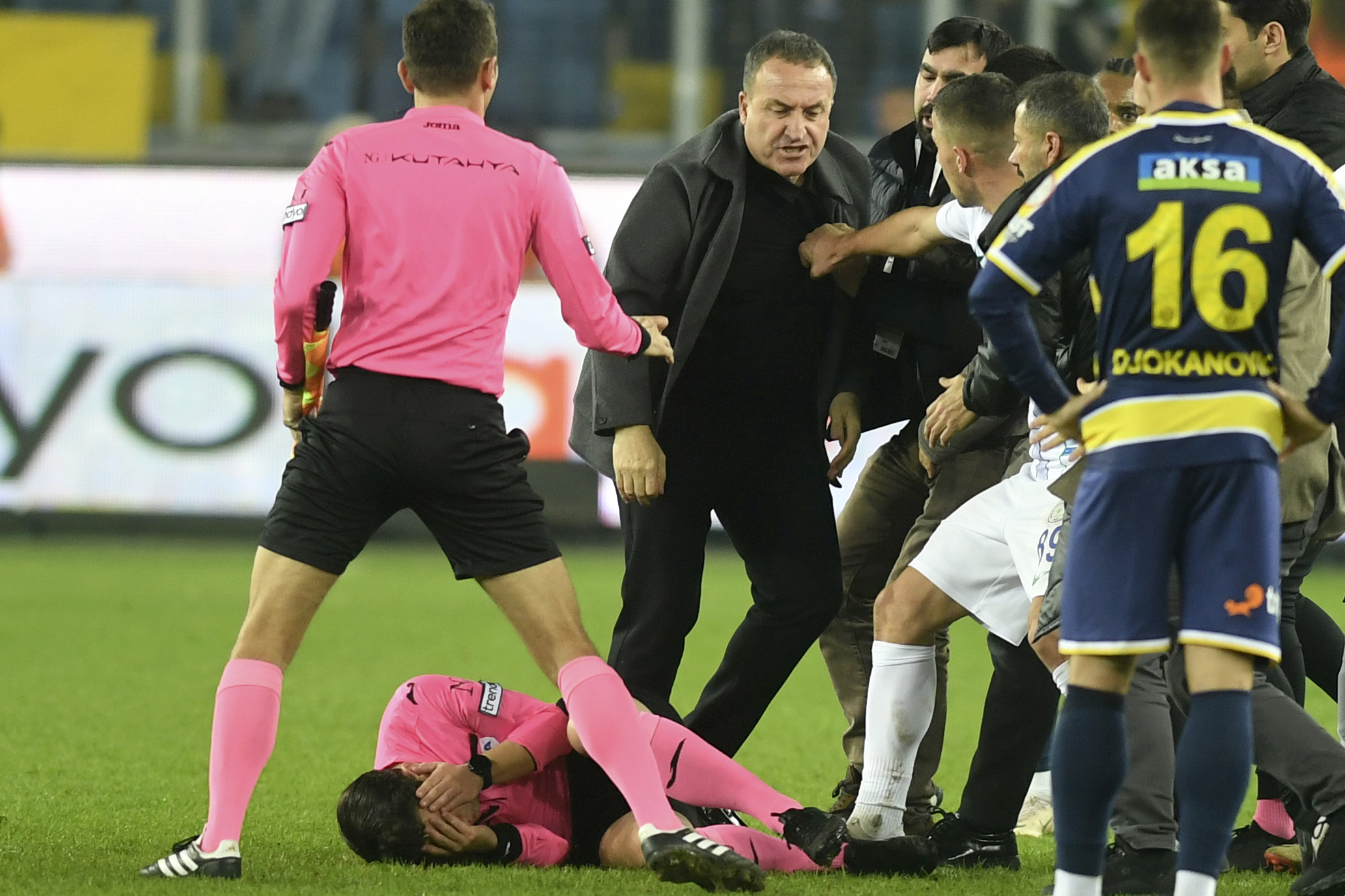 Referee Halil Umut Meler lies on the ground after being struck by MKE Ankaragucu president Faruk Koca, centre