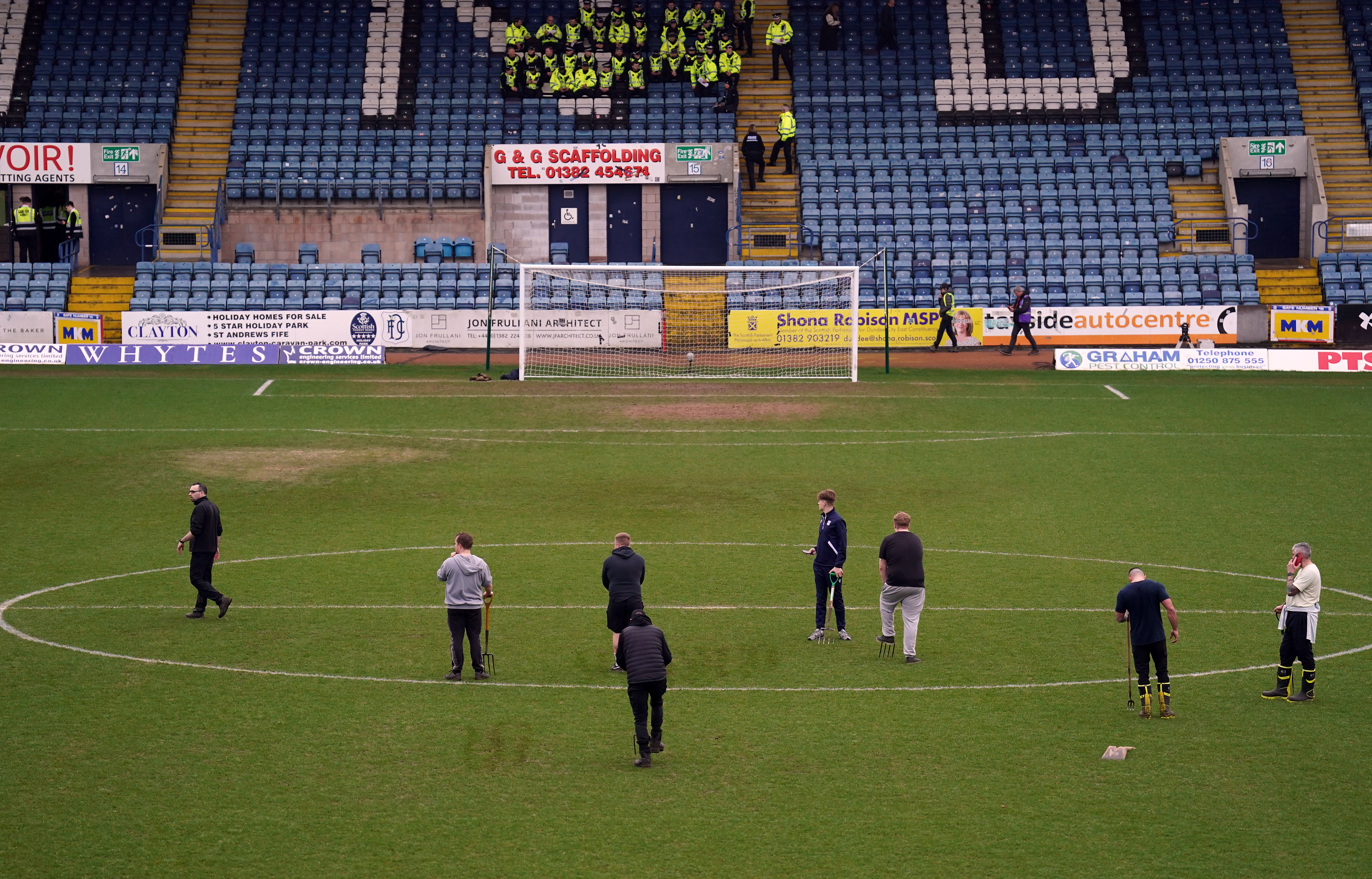 Ground staff work on the pitch