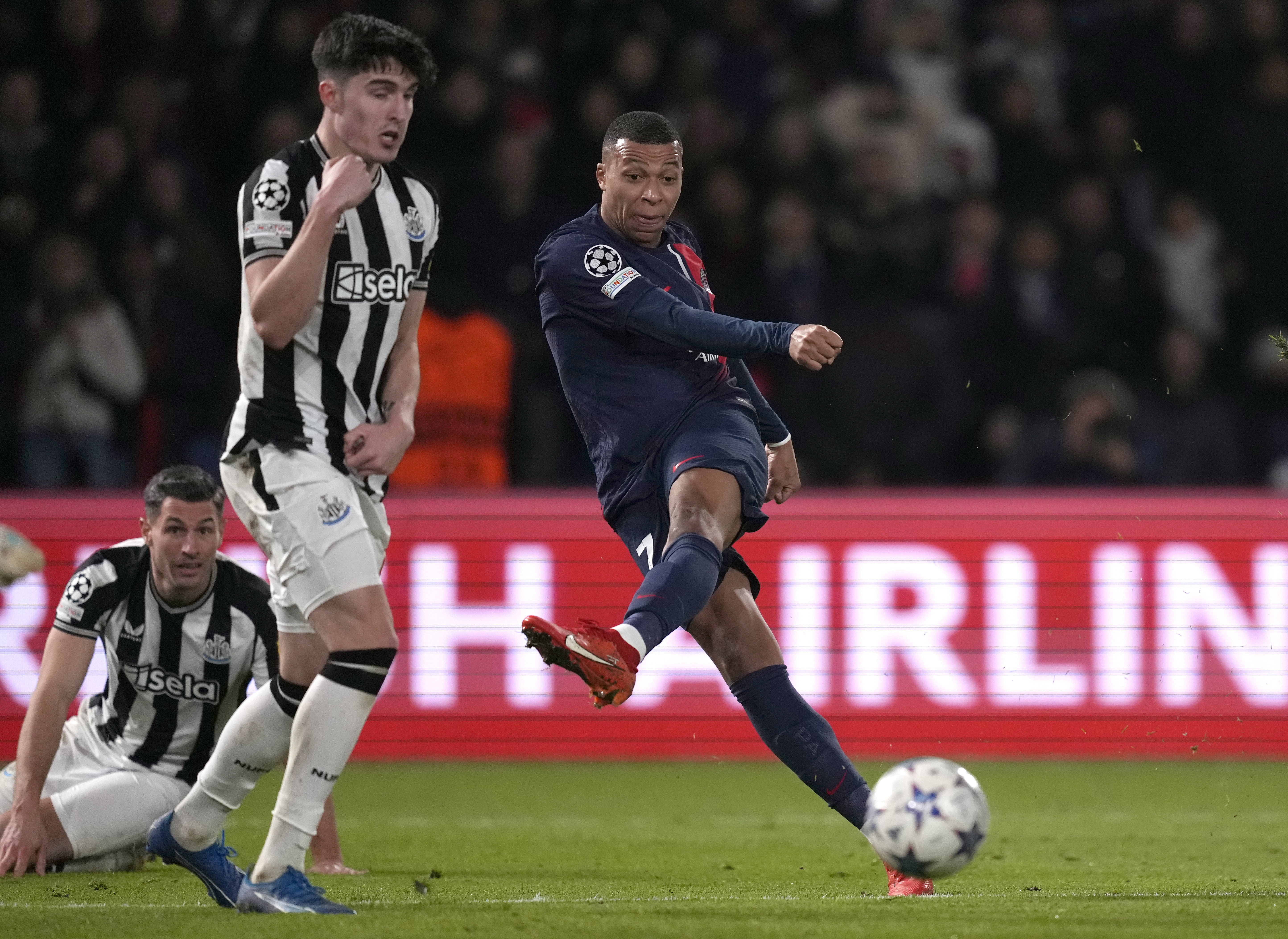 Kylian Mbappe, right, takes a shot under pressure from Tino Livramento
