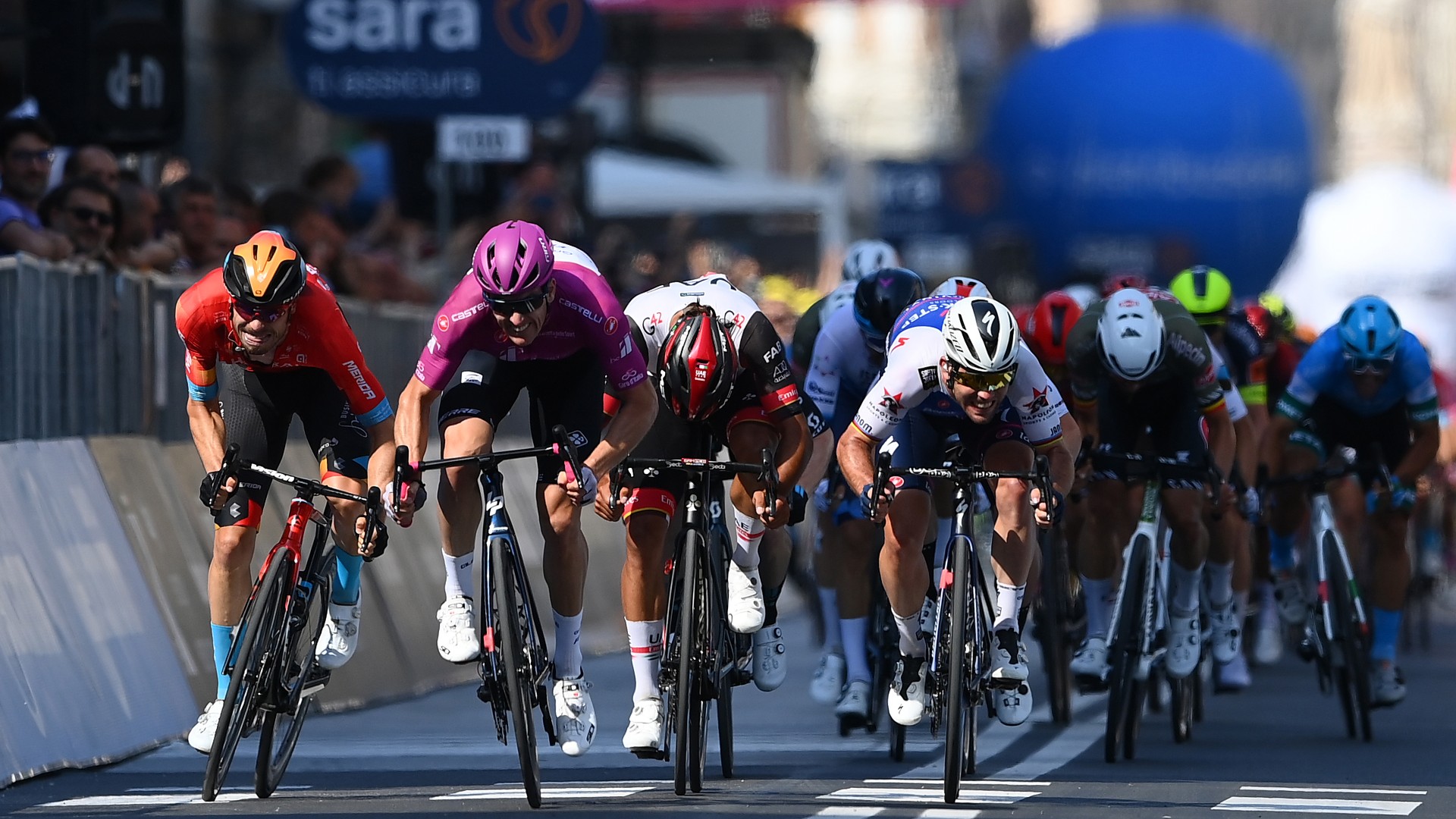 Arnaud Demare, wearing the maglia ciclamino, claims victory