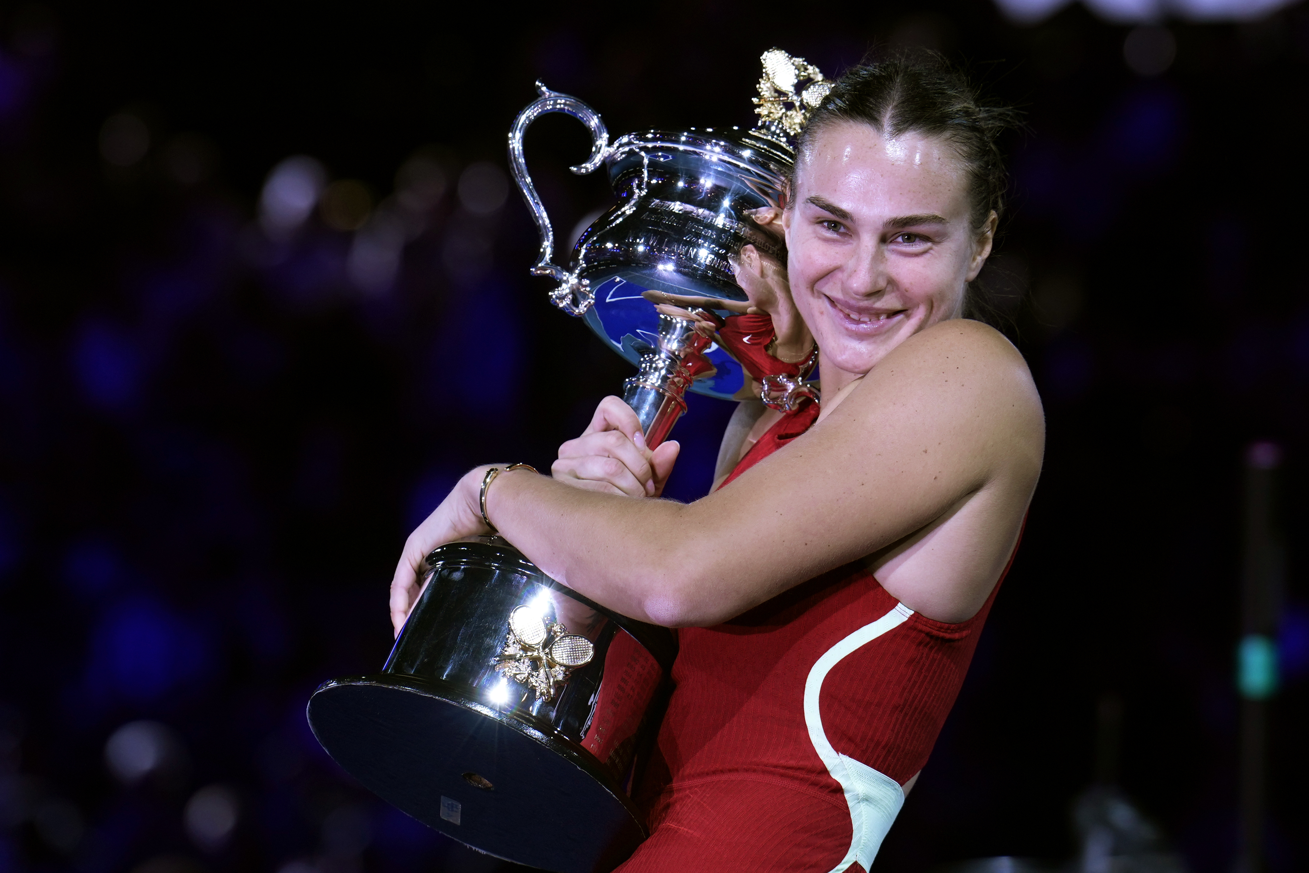 Aryna Sabalenka hugs the trophy