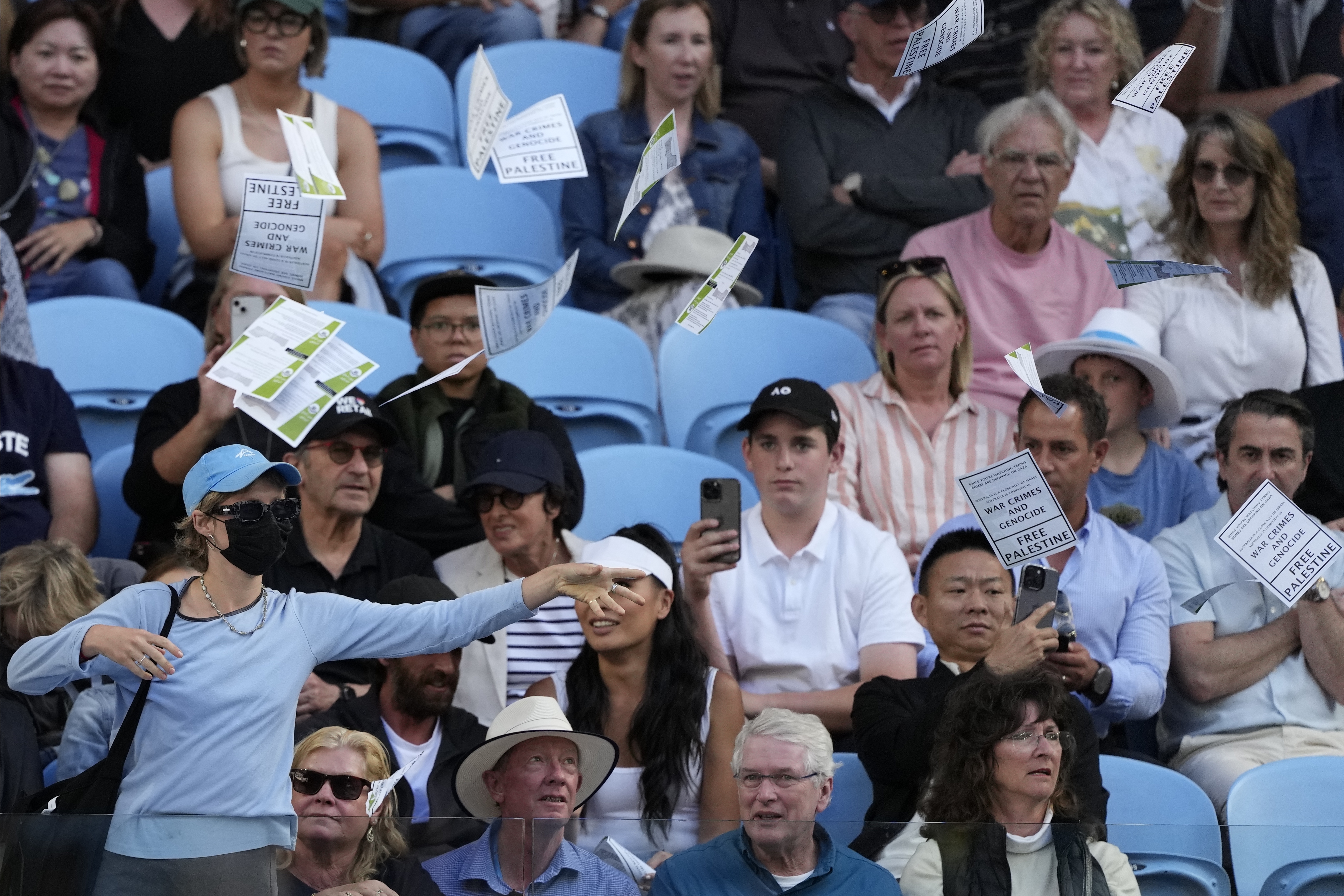 A woman throws 'Free Palestine' leaflets onto Margaret Court Arena