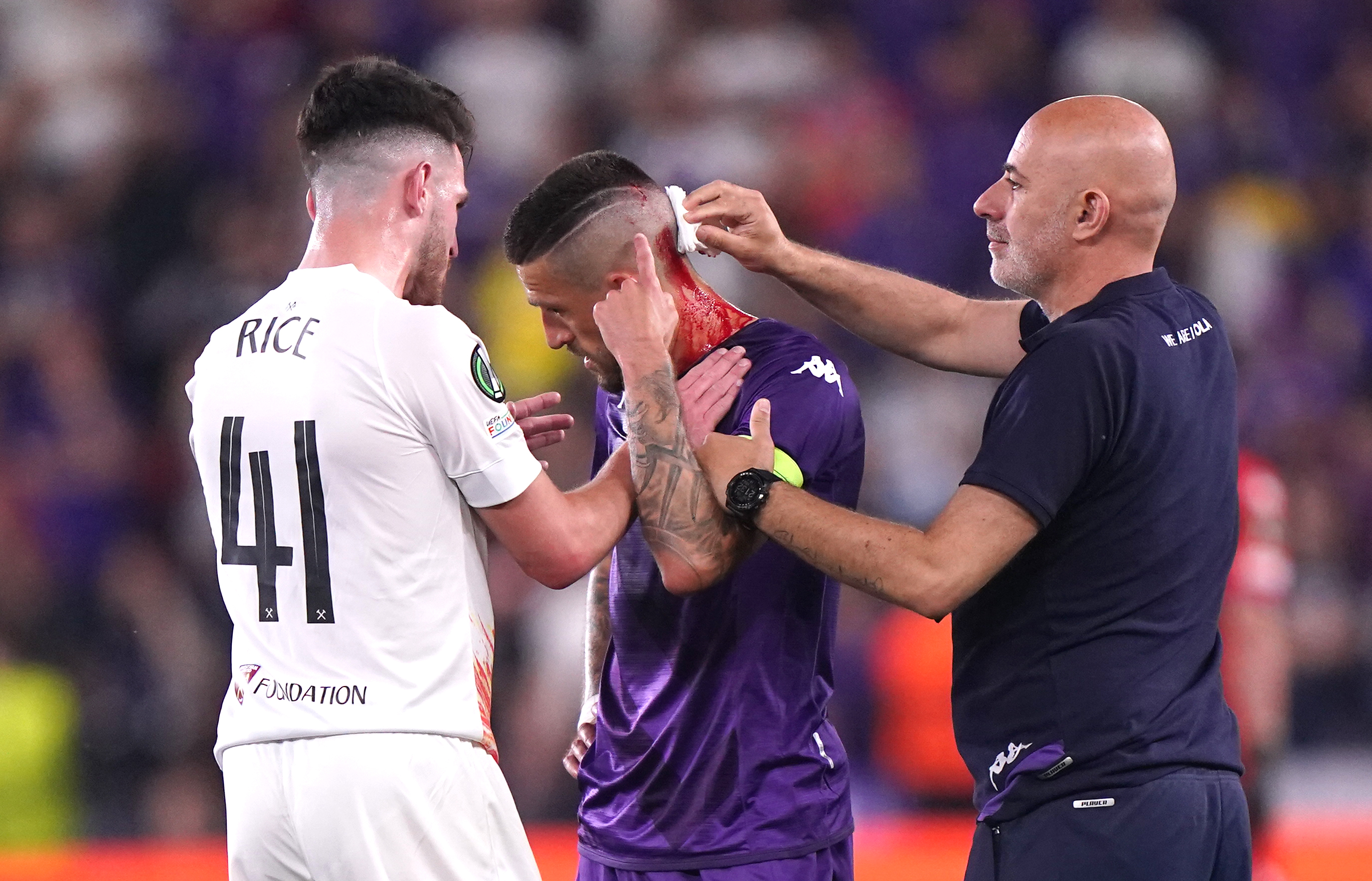 Fiorentina’s Cristiano Biraghi receives treatment for a cut head