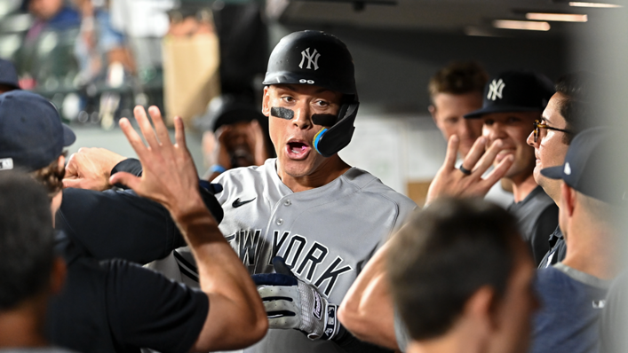 Aaron Judge of the New York Yankees celebrates with teammates after hitting a solo home run during the ninth inning against the Seattle Mariners