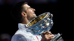 Novak Djokovic, in his '22' jacket, holds the Australian Open trophy