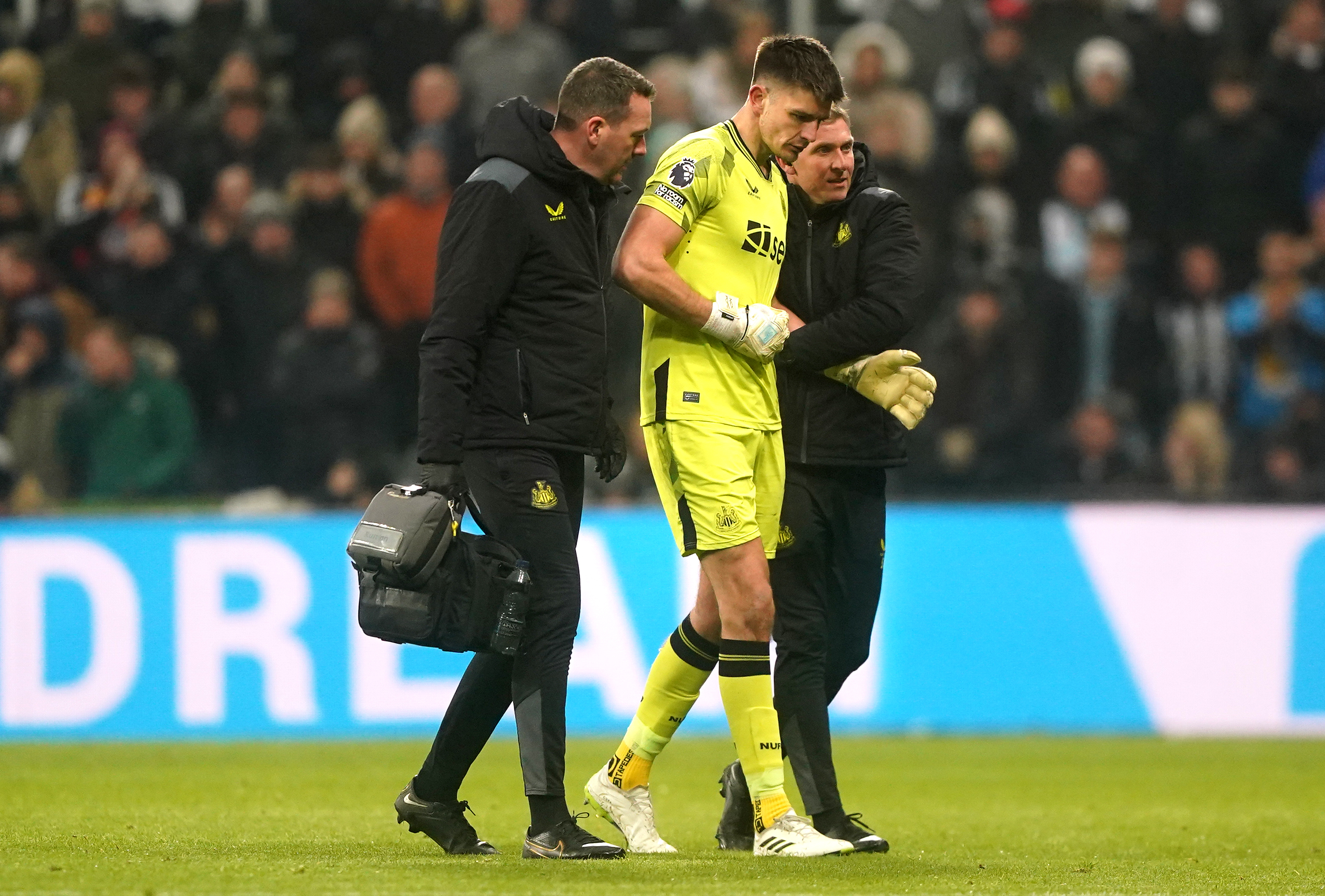 Newcastle goalkeeper Nick Pope (centre) is helped off