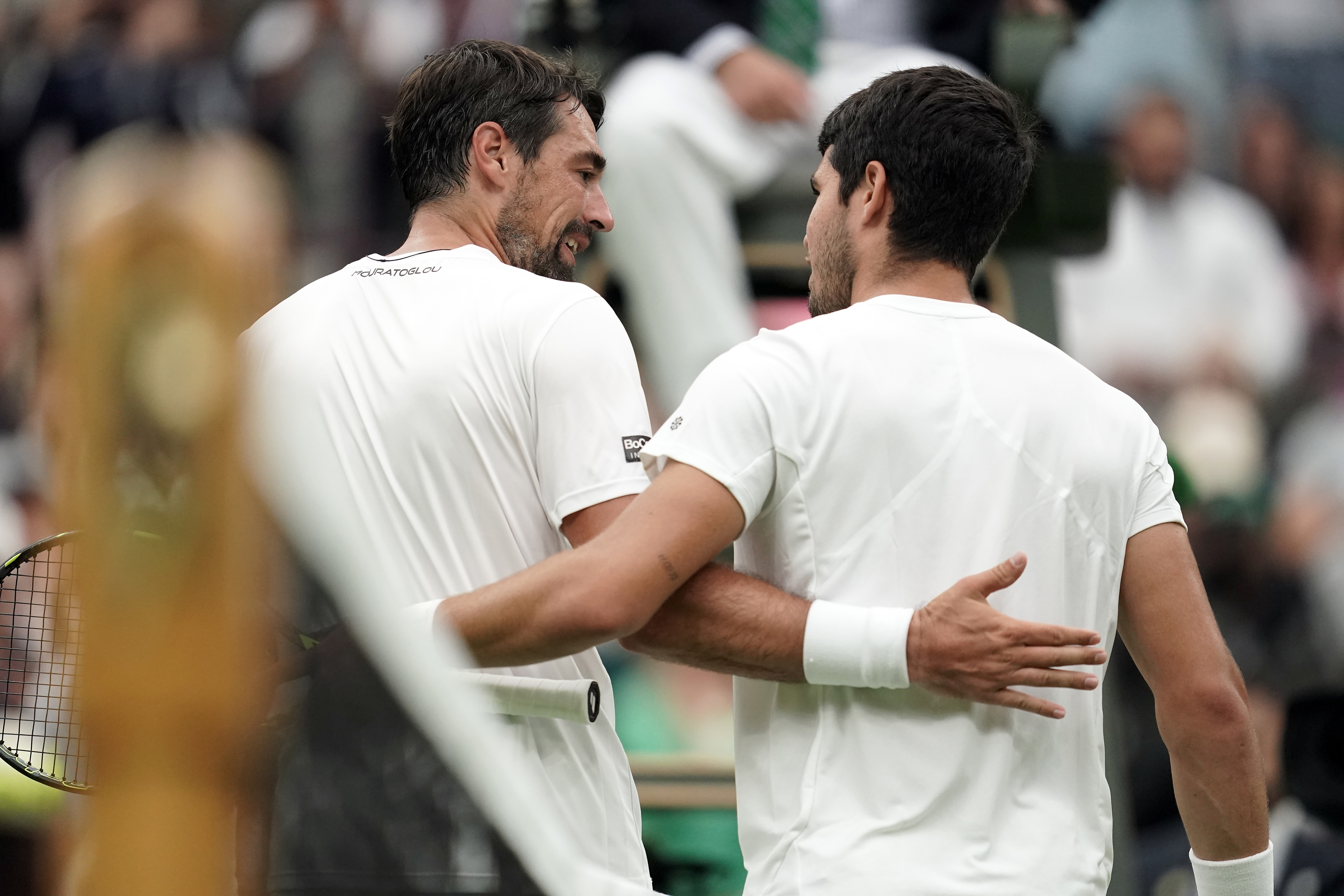 Carlos Alcaraz and Jeremy Chardy (left) embrace at the net after their match