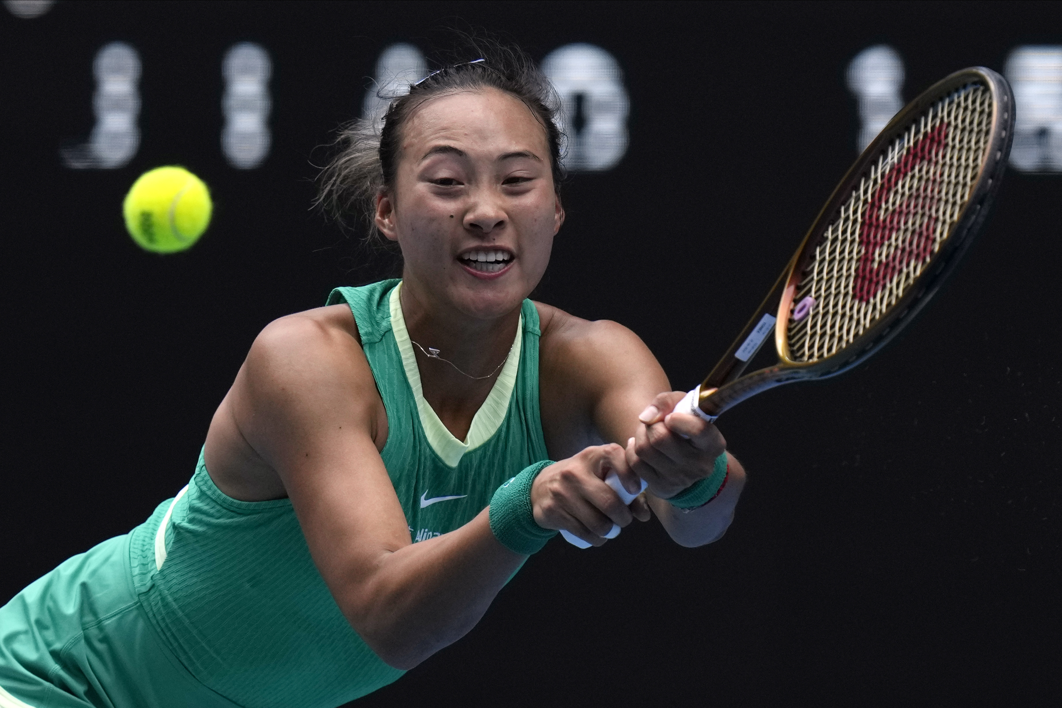 Zheng Qinwen plays a backhand