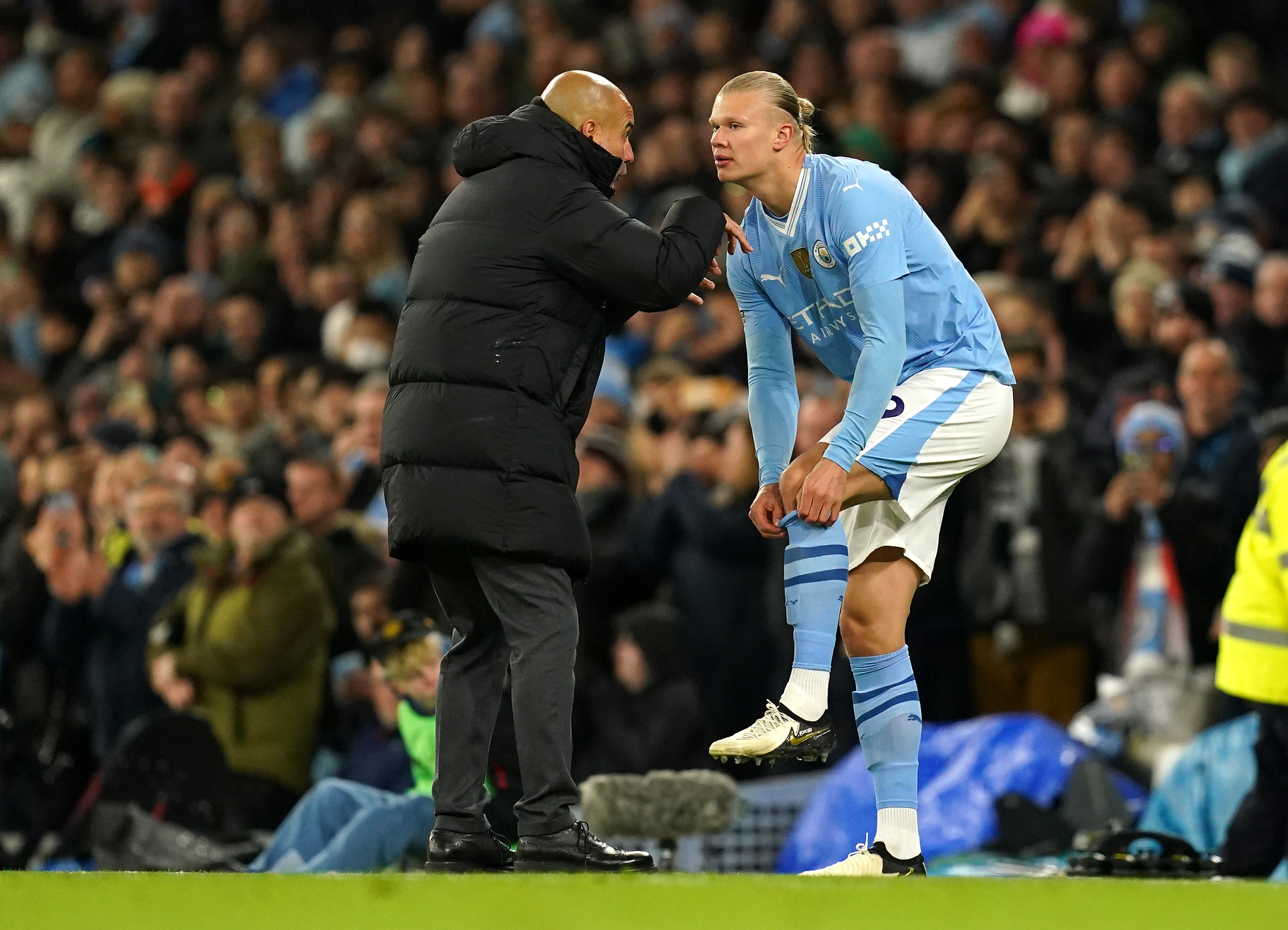 Manchester City manager Pep Guardiola speaks with Erling Haaland