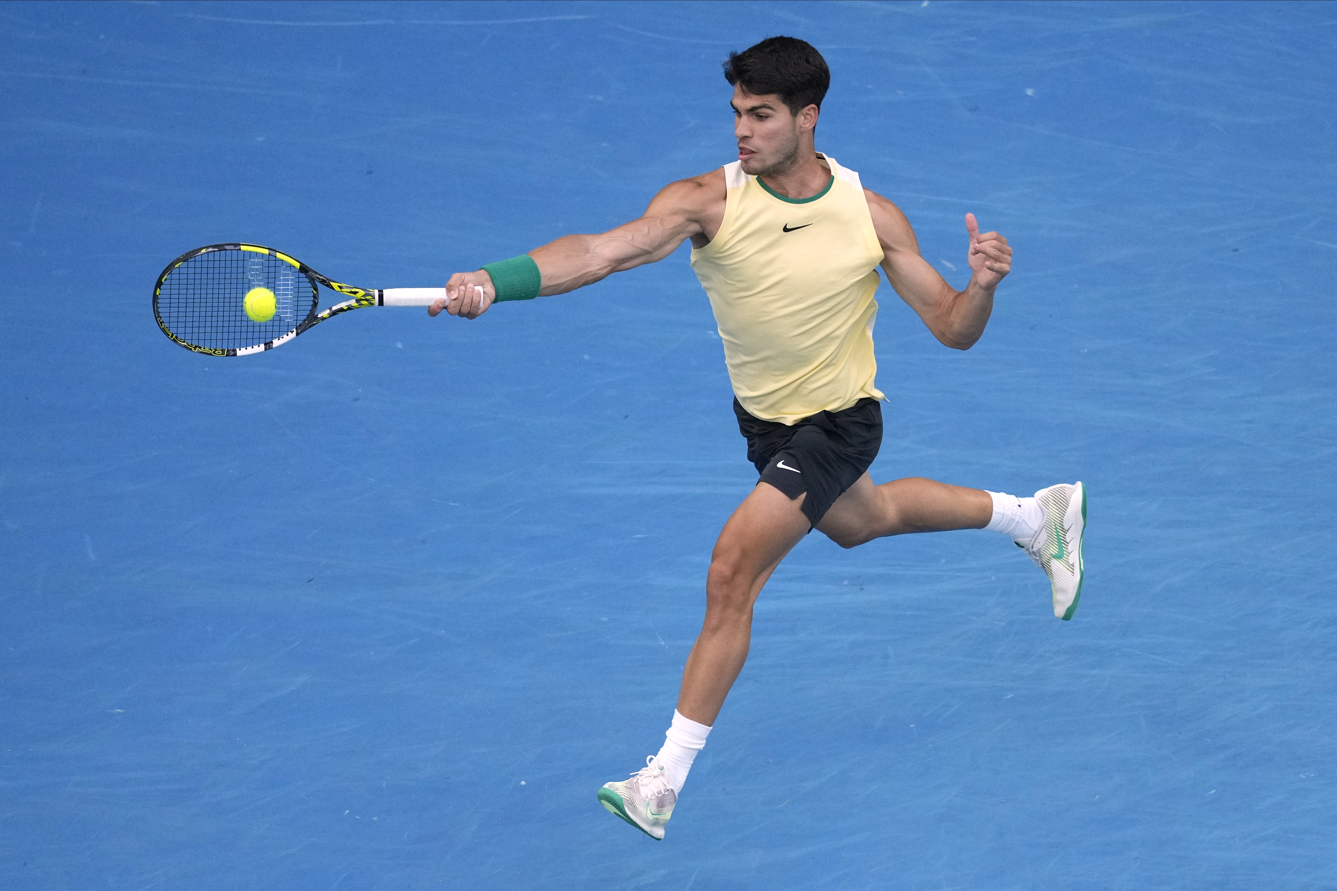 Carlos Alcaraz leaps into a forehand