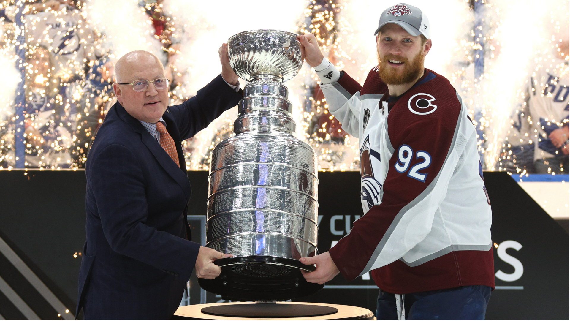 Colorado Avalanche captain Gabriel Landeskog is presented with the Stanley Cup by NHL deputy commissioner Bill Daly