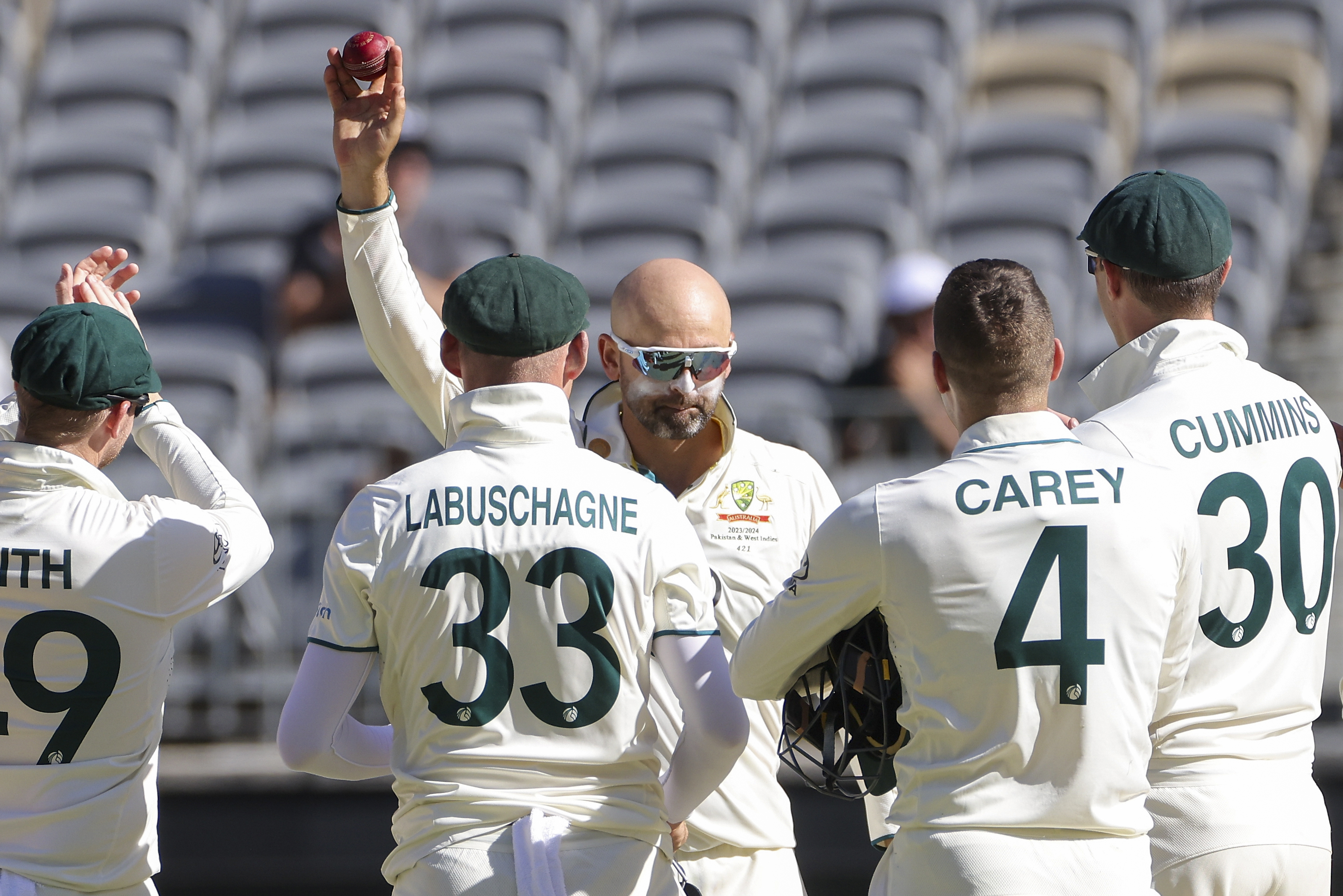 Australia’s Nathan Lyon (centre} holds the ball aloft after dismissing Pakistan’s Faheem Ashraf to claim his 500th Test match wicket