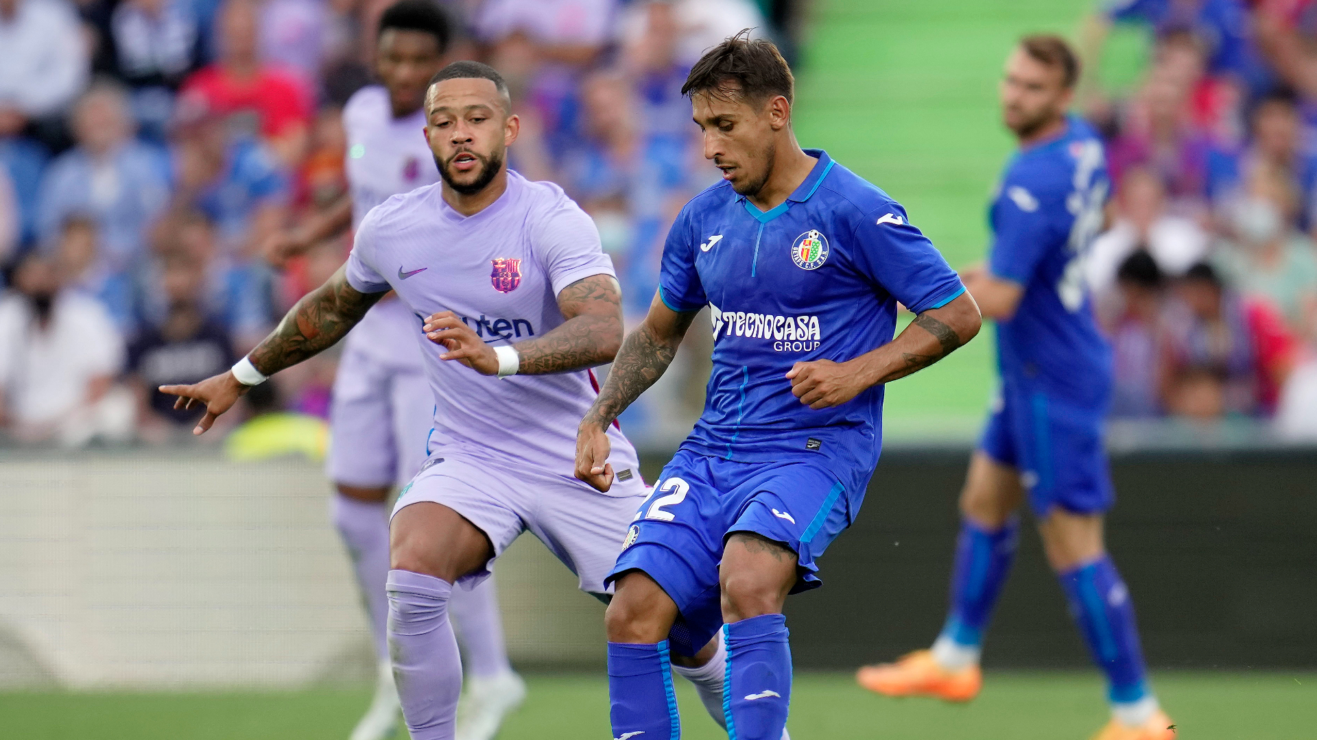 Memphis Depay (l) and Damian Suarez (r) contest the ball during Getafe v Barcelona