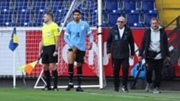 Ronald Araujo is helped from the field during Uruguay's match against Iran
