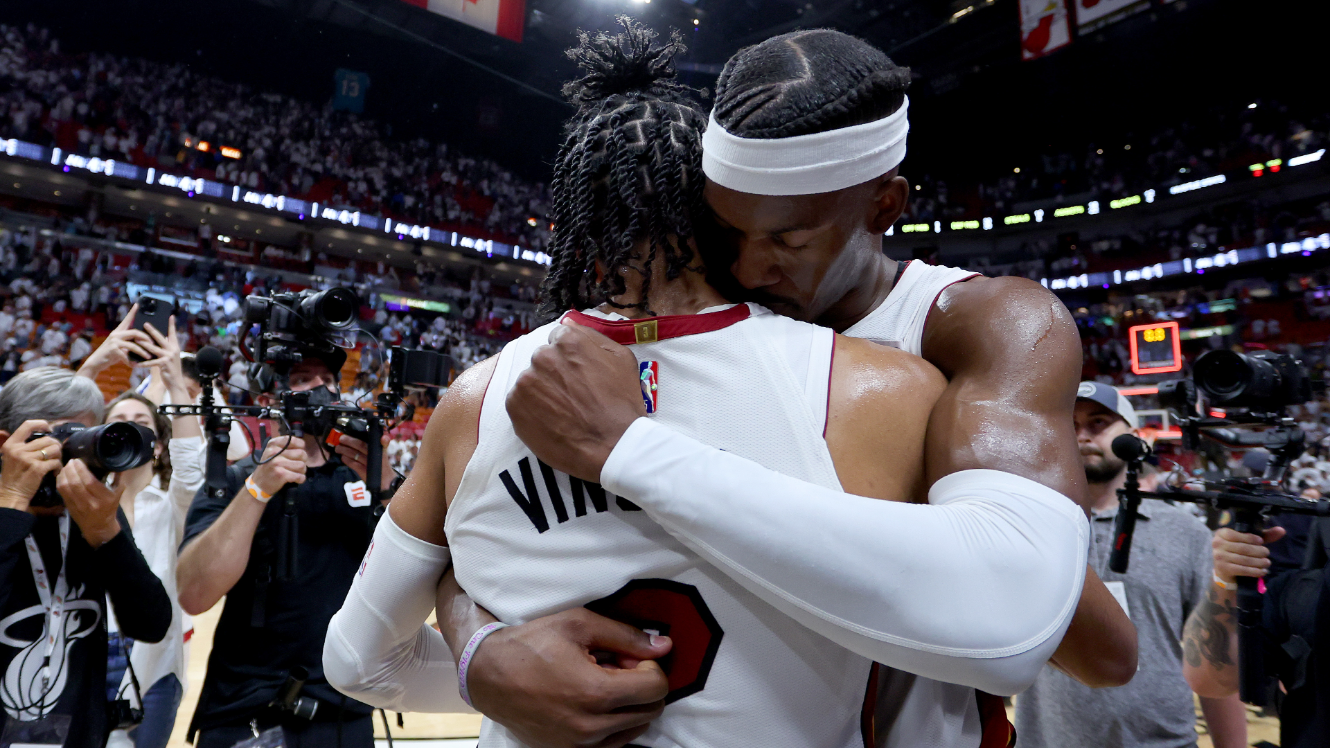 Jimmy Butler of the Miami Heat hugs teammate Gabe Vincent after defeating the Boston Celtics