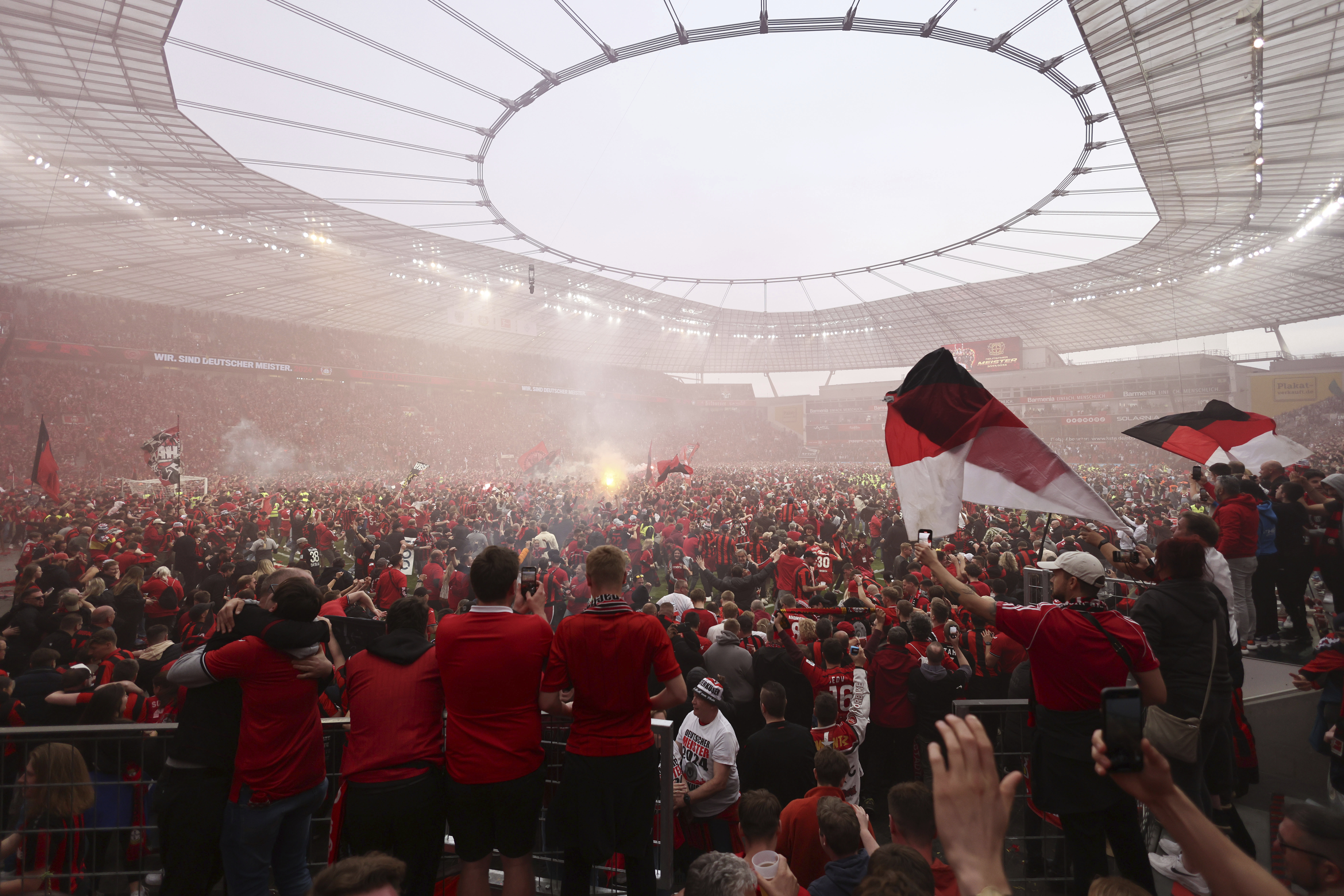 Bayer Leverkusen fans invade the pitch to celebrate their team's Bundesliga title win