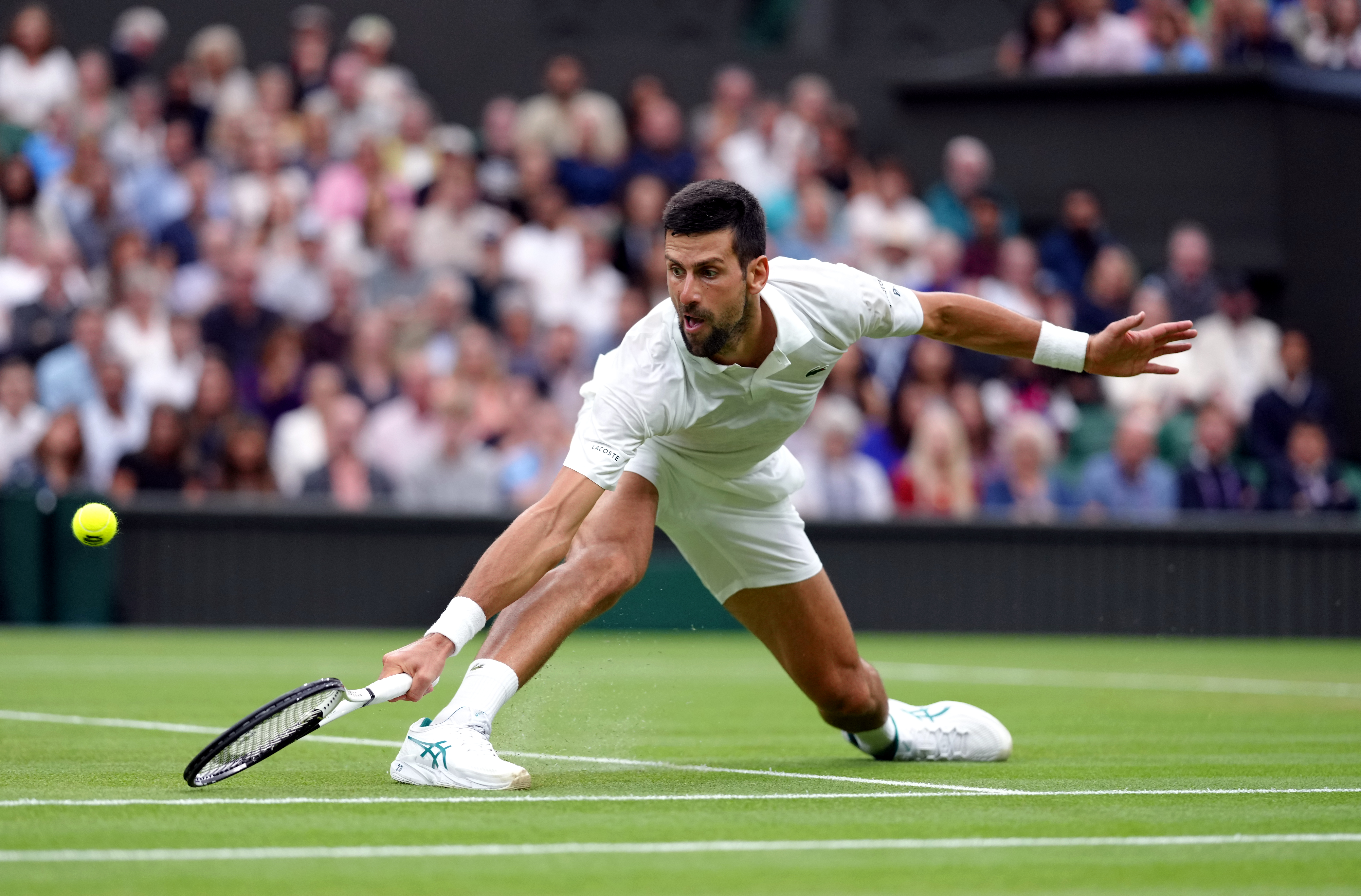 Novak Djokovic slides into a backhand