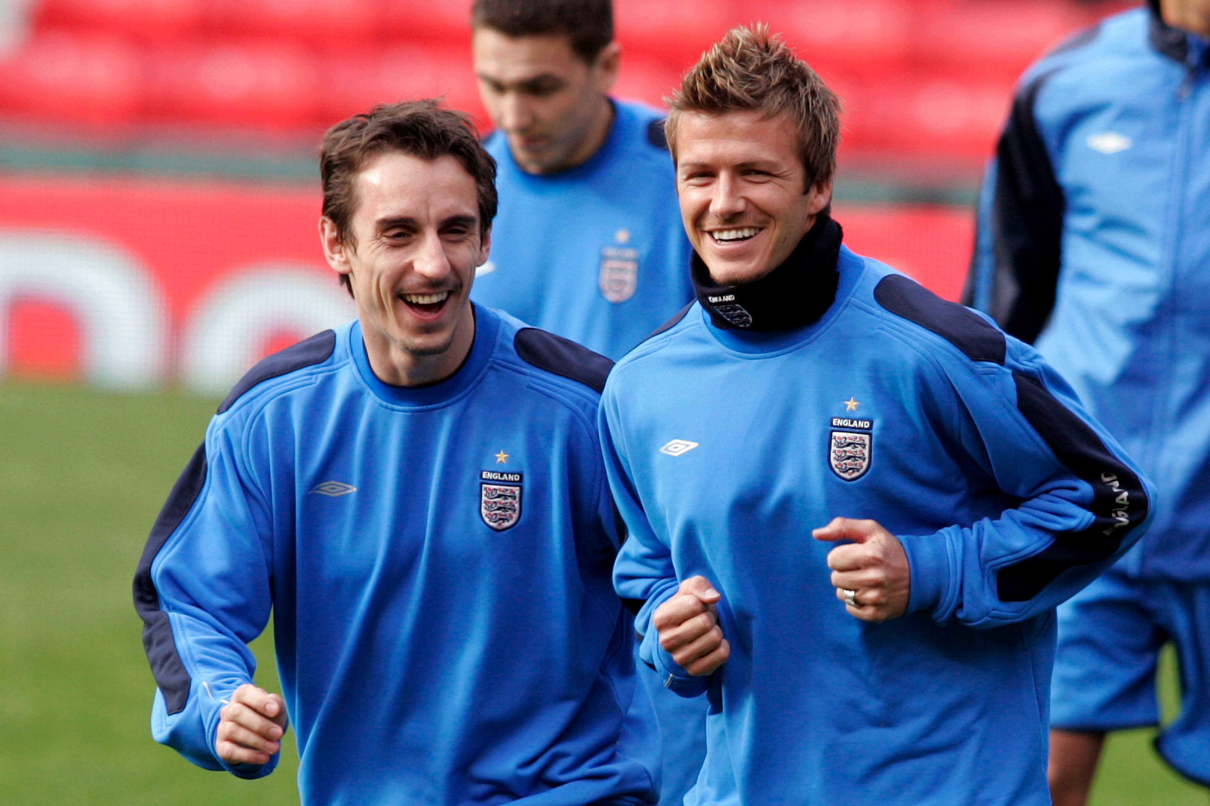 Gary Neville (left) shares a joke with David Beckham during a training session