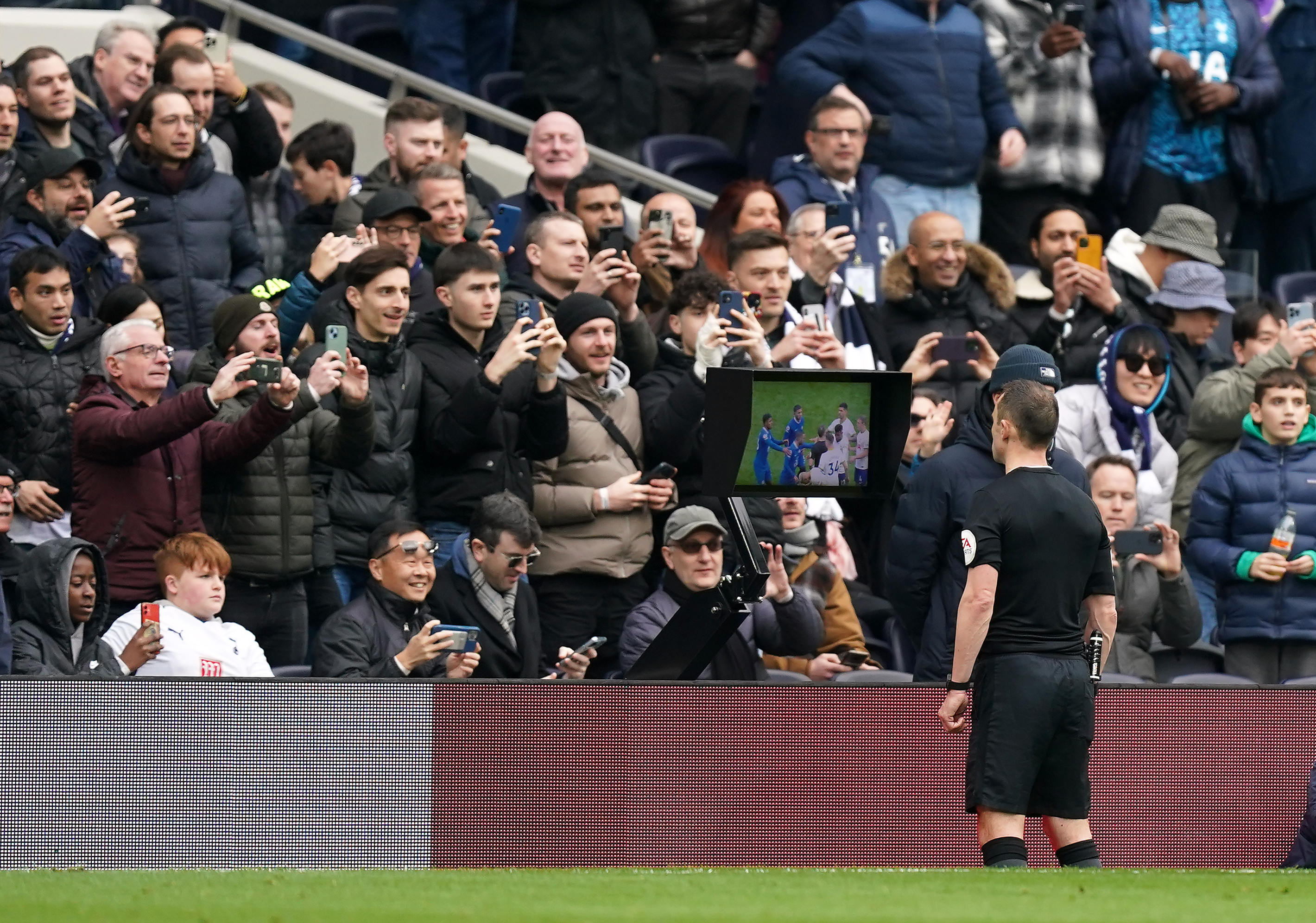 Referee Stuart Attwell checks the pitchside VAR monitor during the Tottenham v Chelsea match on February 26