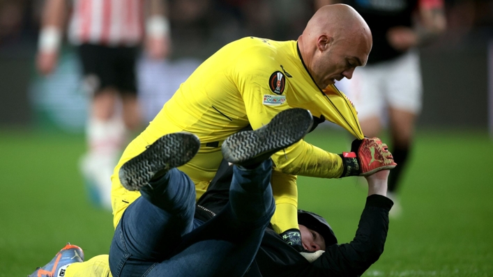 Marko Dmitrovic pins a fan during Sevilla's Europa League game with PSV