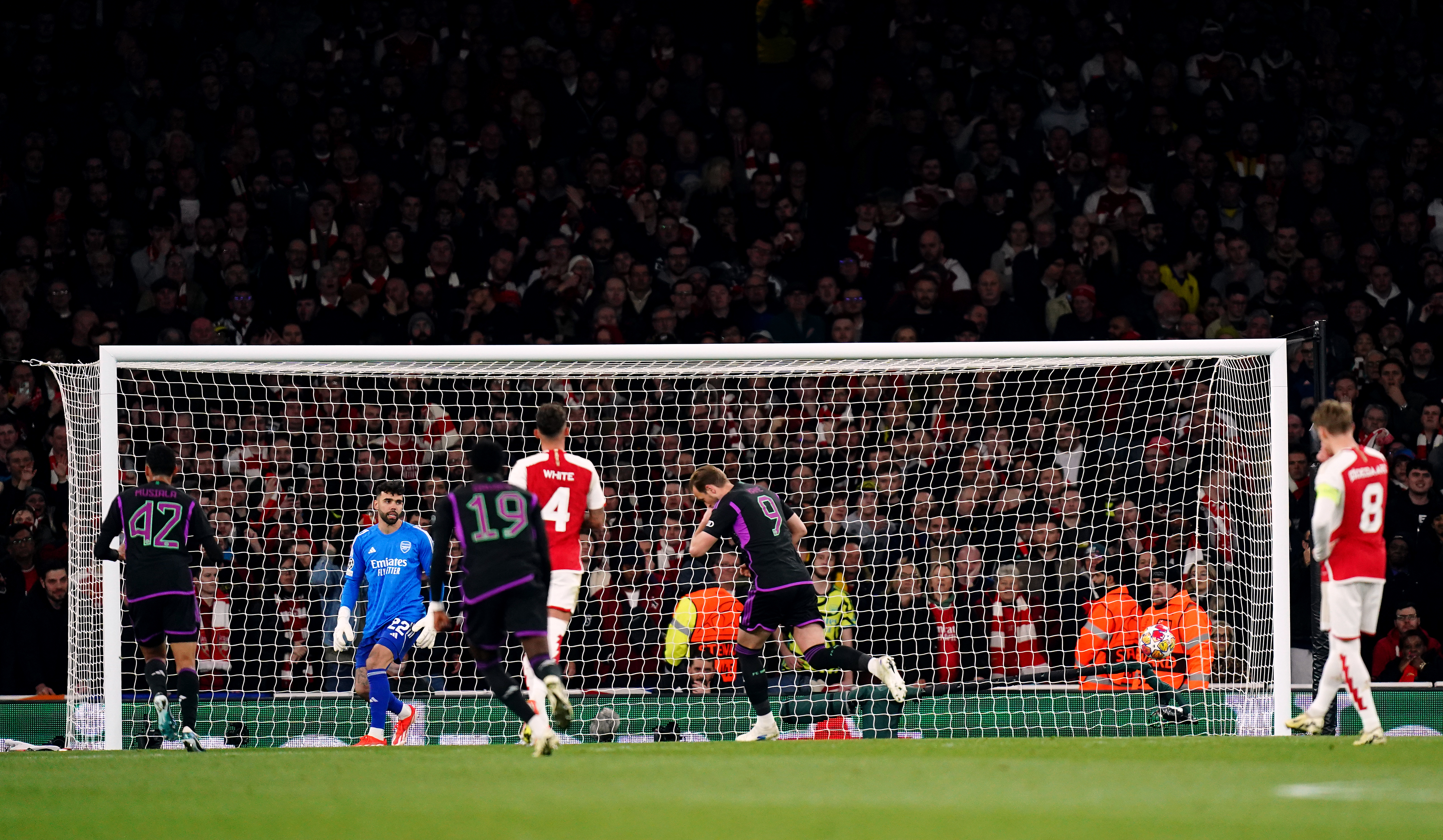 Bayern Munich's Harry Kane, centre right, turns away in celebration after scoring from the penalty spot against Arsenal