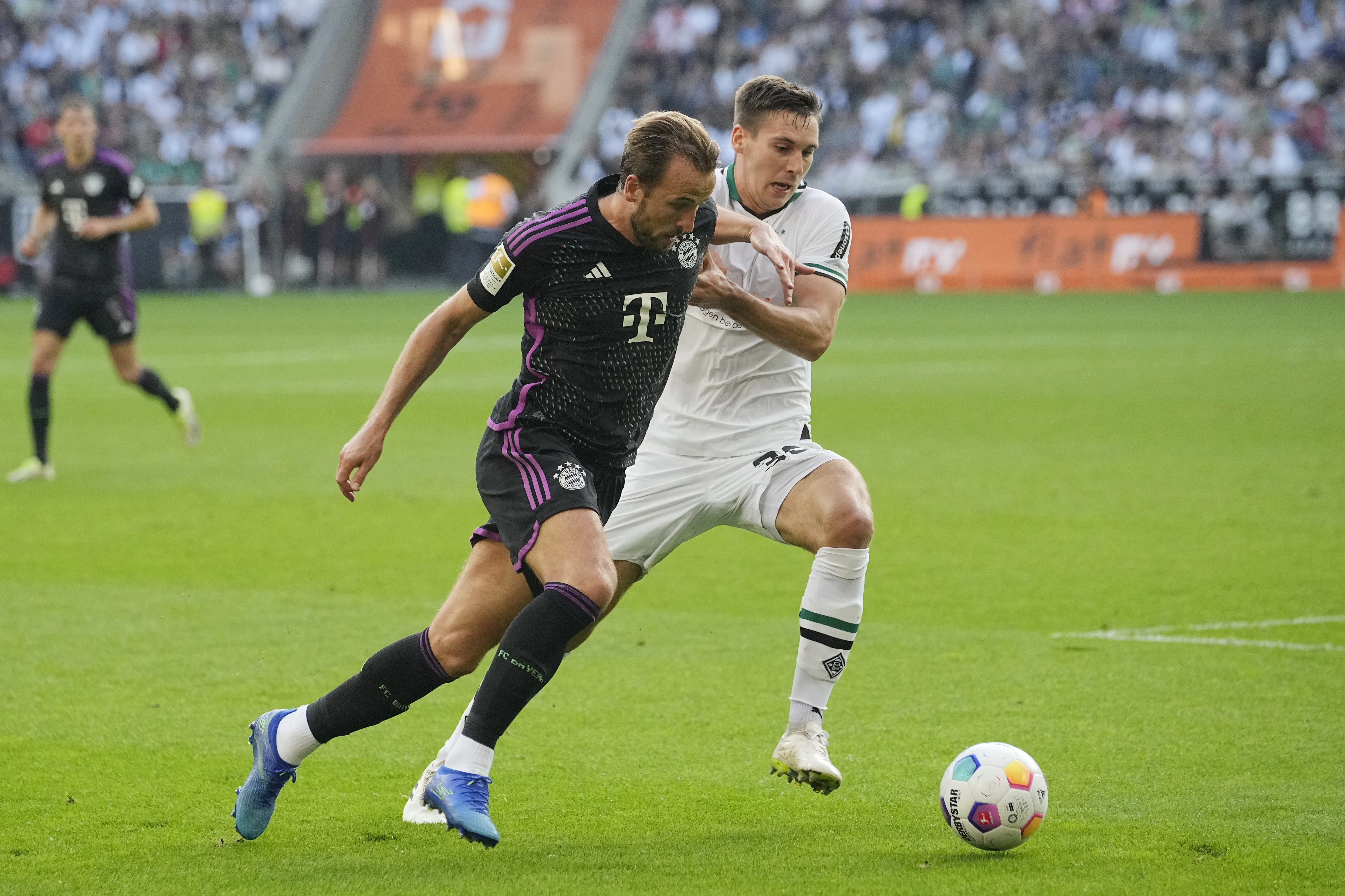 Bayern Munich’s Harry Kane (left) in action against Borussia Monchengladbach