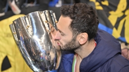 Hakan Calhanoglu kisses the Supercoppa Italiana trophy