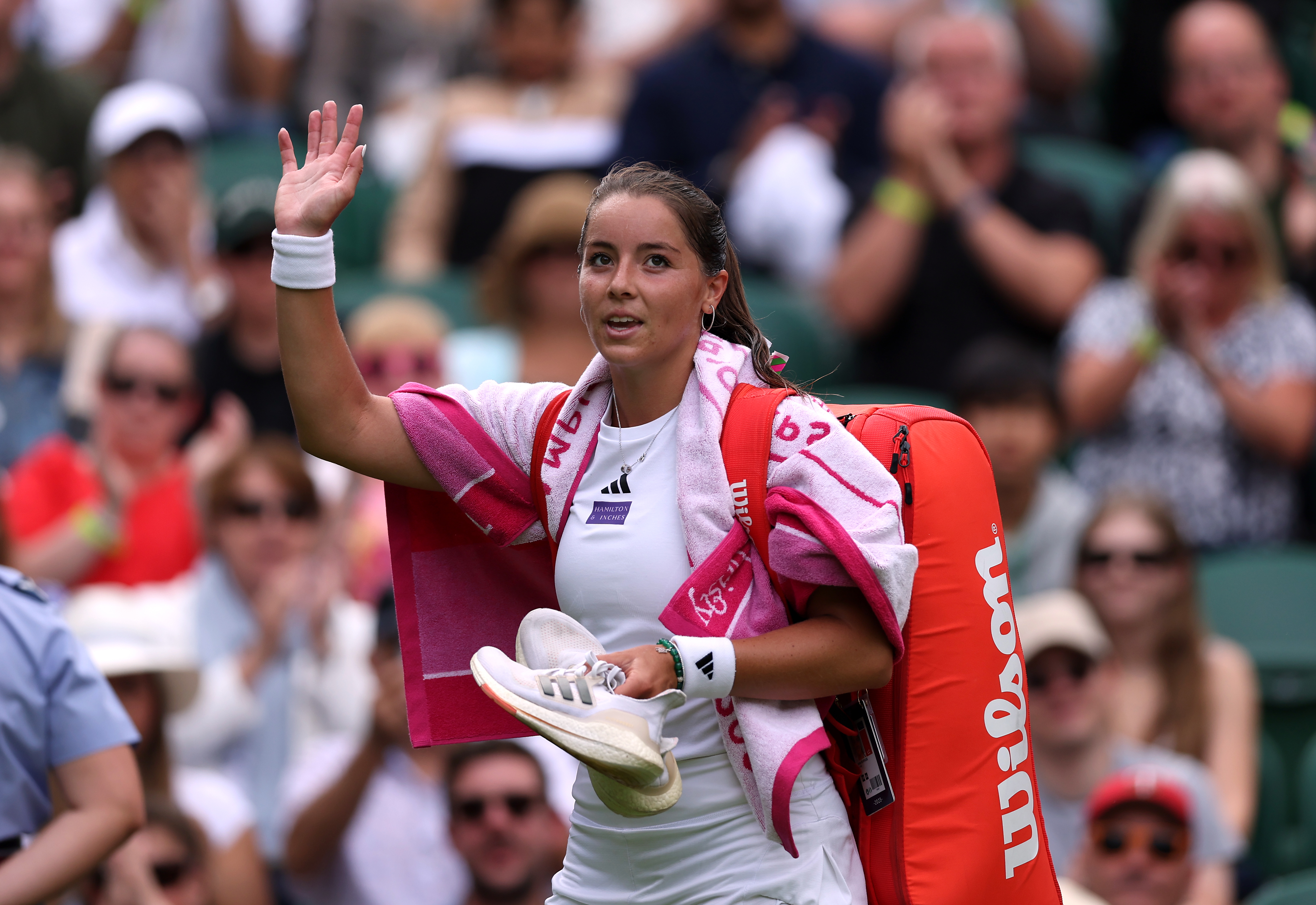 Jodie Burrage waves to the crowd as she leaves court after her match against Daria Kasatkina