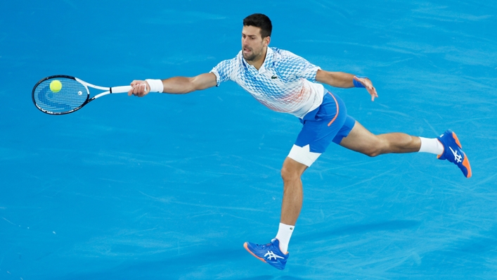Novak Djokovic, with strapping on his left leg, reaches for a ball in his second-round win