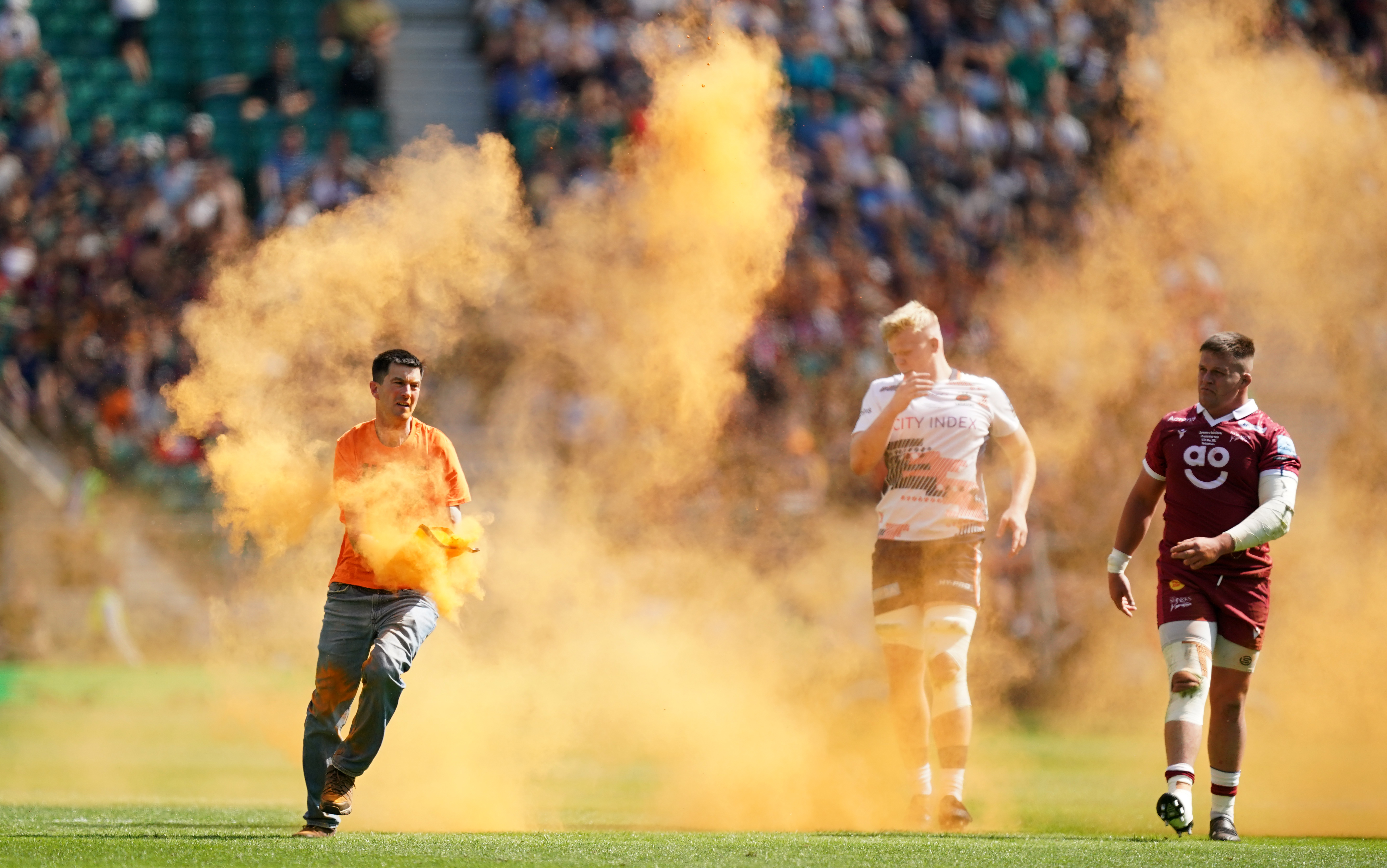 A Just Stop Oil protester throws orange powder on the pitch during the Gallagher Premiership final
