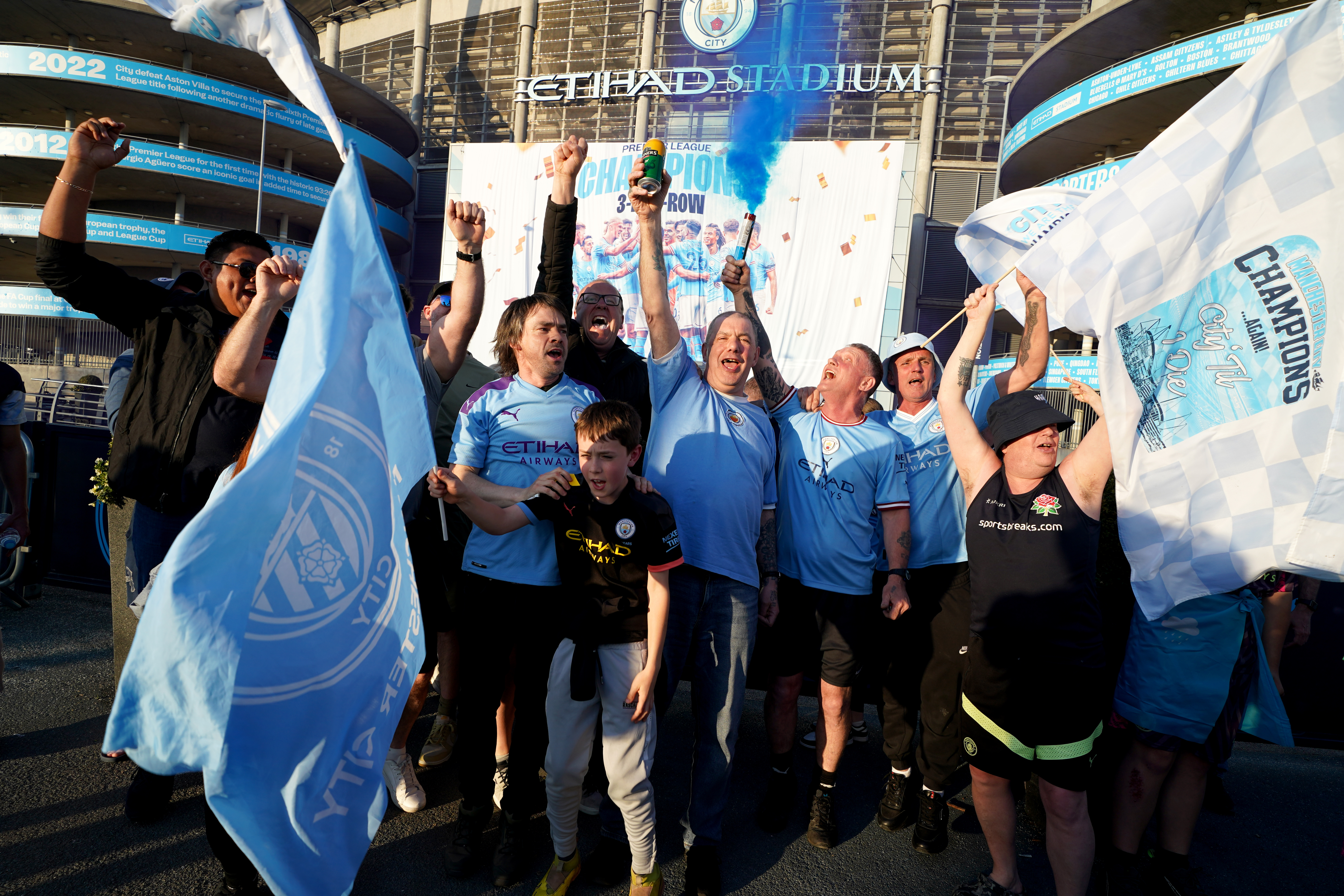 Manchester City fans celebrate outside of the Etihad Stadium