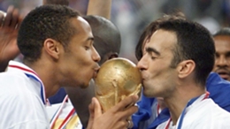 Youri Djorkaeff (right) and Thierry Henry kiss the World Cup trophy in 1998