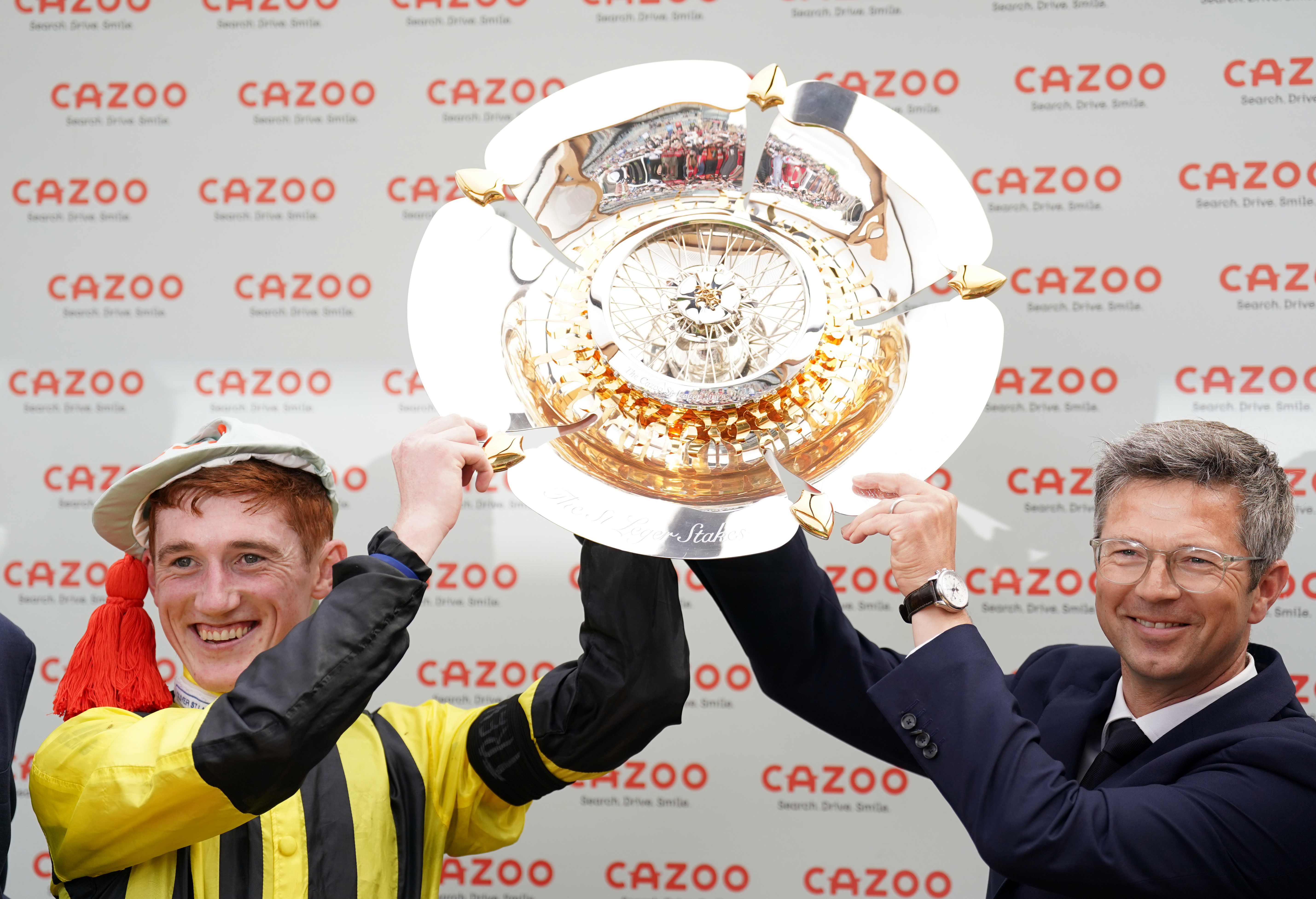 David Egan and Roger Varian lift the trophy after winning the Cazoo St Leger at Doncaster