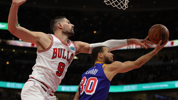 Nikola Vucevic of the Chicago Bulls defends a shot by Stephen Curry of the Golden State Warriors during the second half of a game at United Center