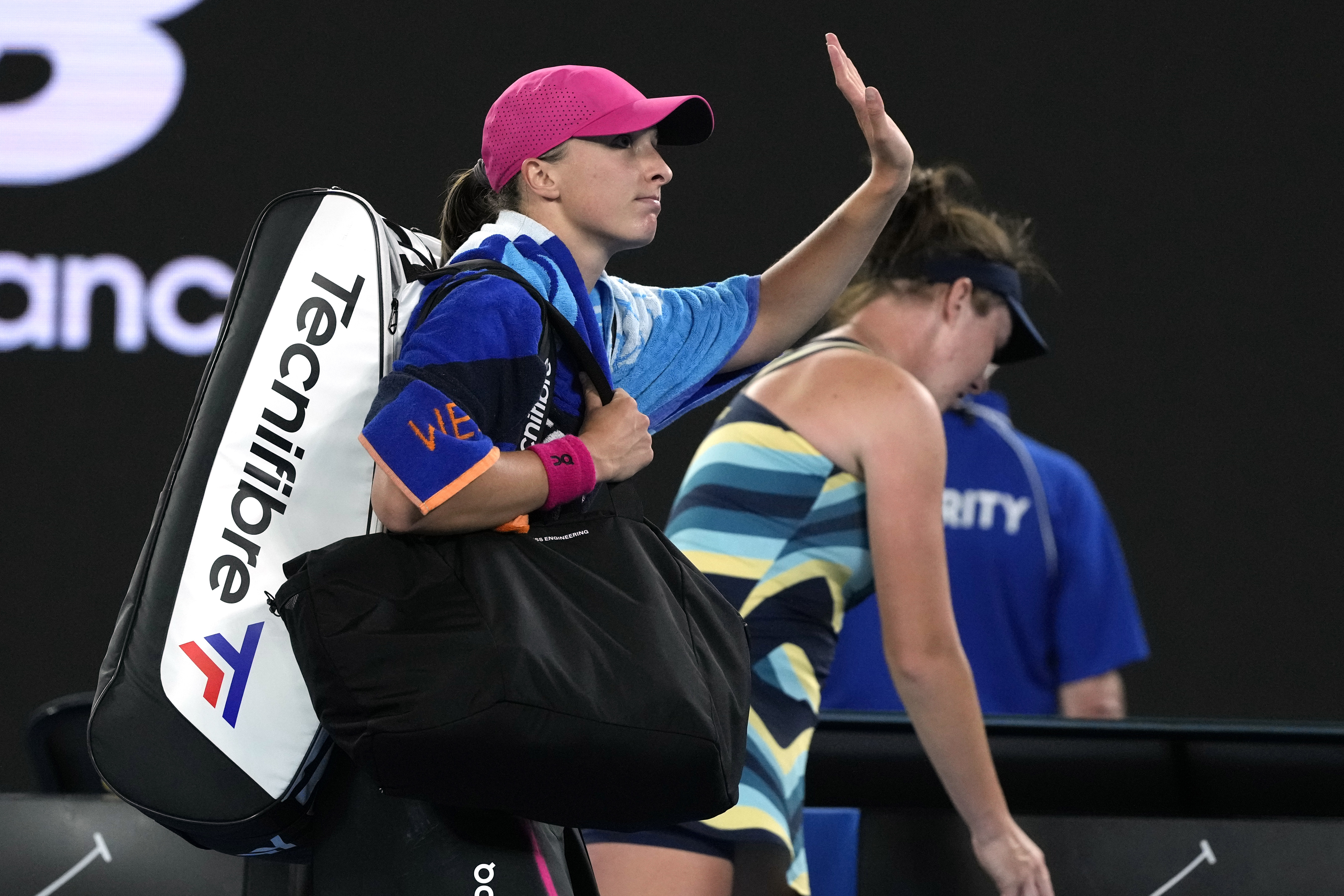 Iga Swiatek waves as she leaves Rod Laver Arena
