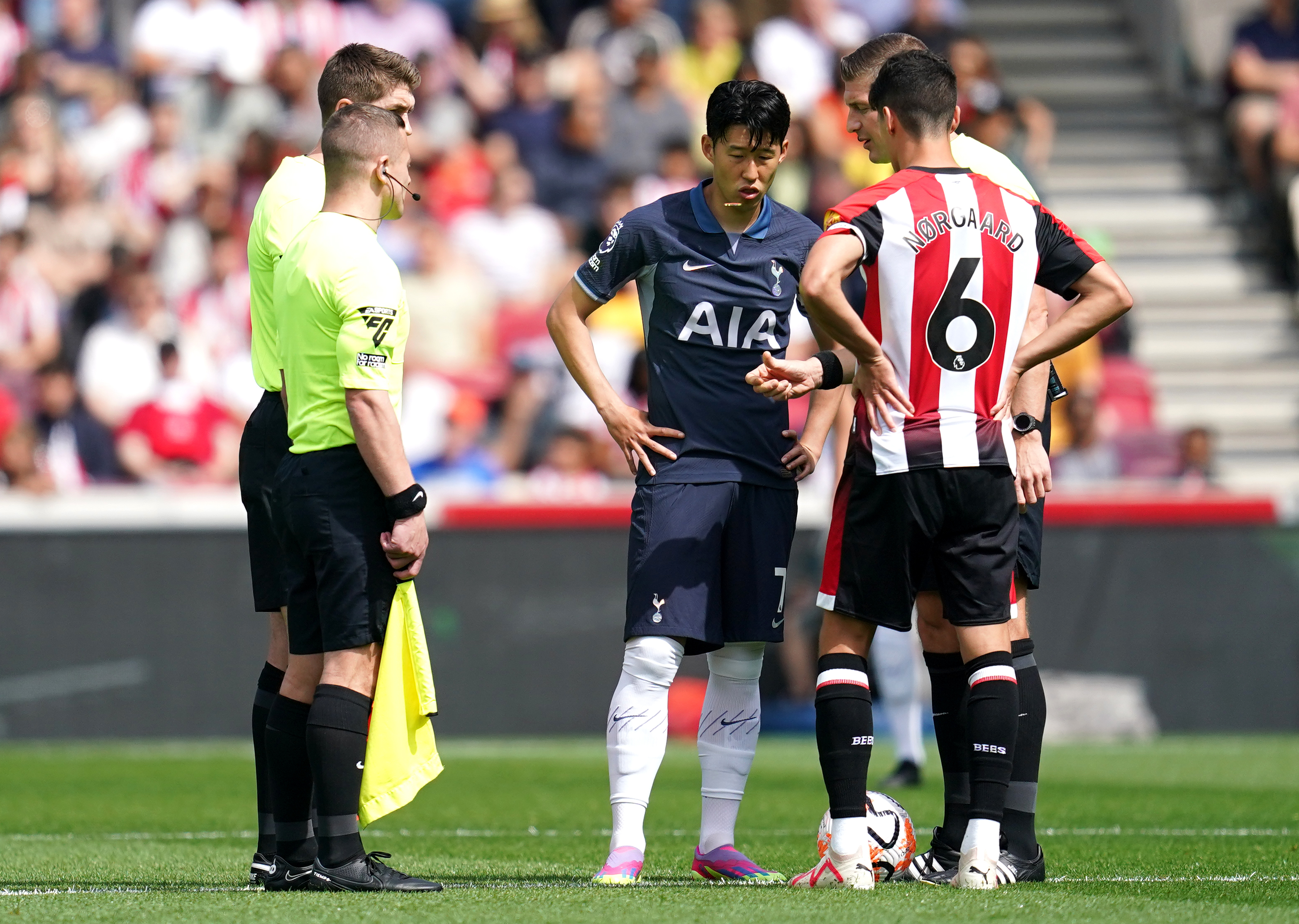 Robert Jones (right) speaks to Tottenham captain Son Heung-min and Brentford skipper Christian Norgaard