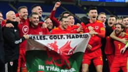 Bale and Wales players hold up the "Wales. Golf. Madrid" flag